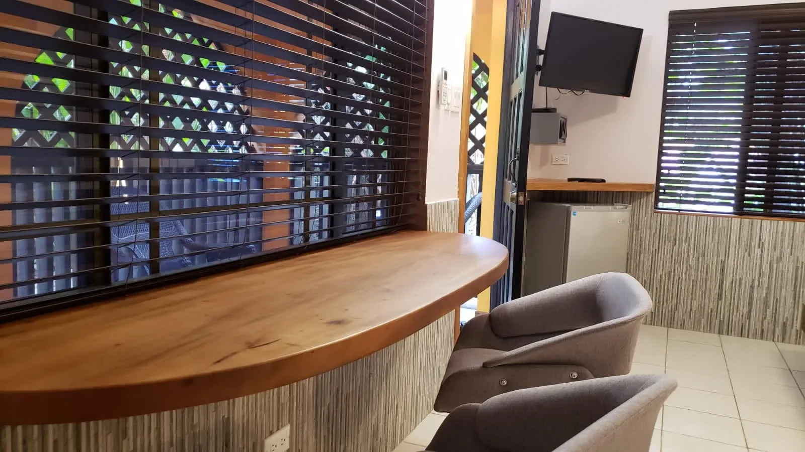Interior de una habitación de Ocean Mist con encimera, sillas y televisor.