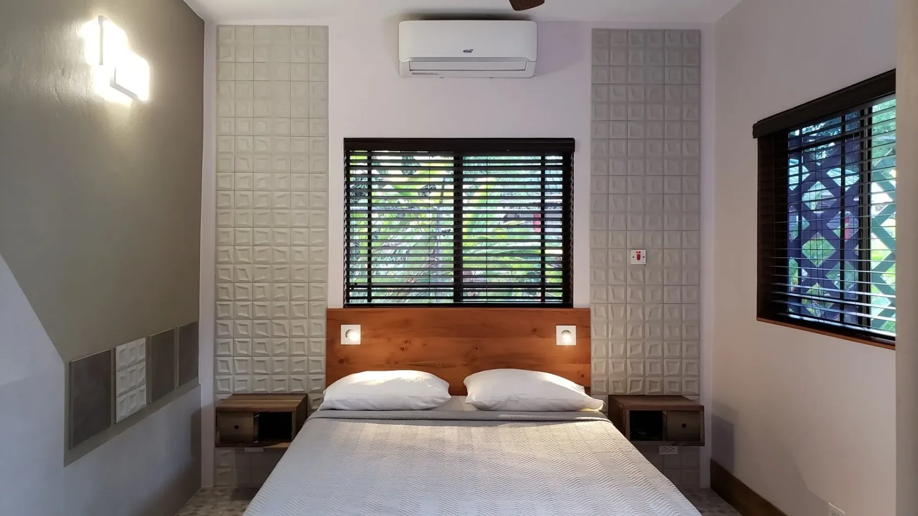 Habitación Stonehenge con una cama, mesas de noche y aire acondicionado de pared.