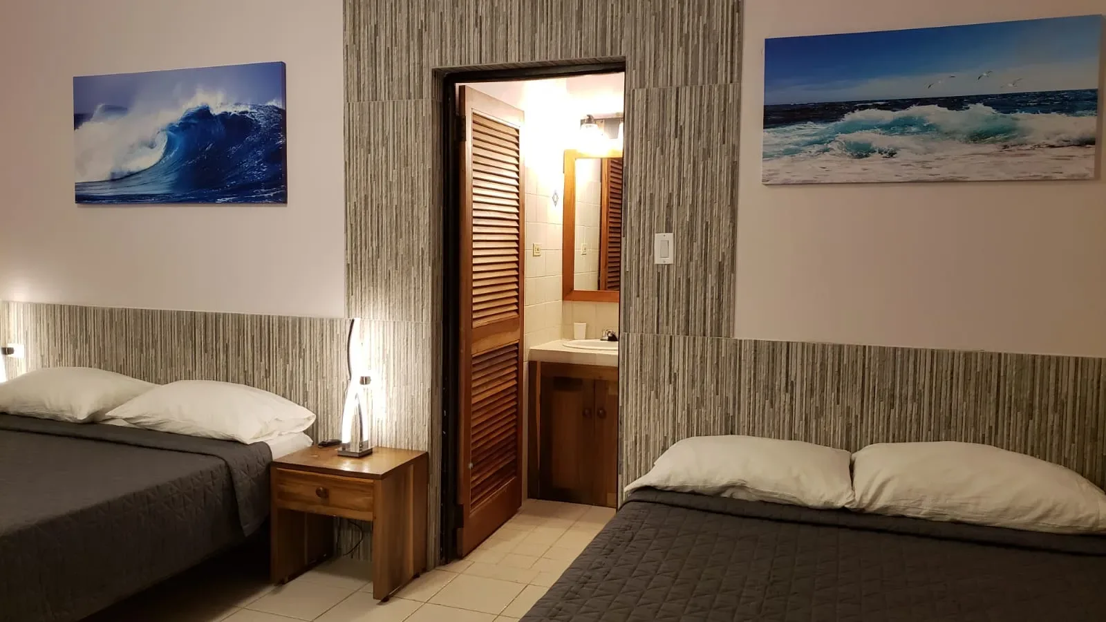Dos camas de Ocean Mist junto a una obra de arte con olas.