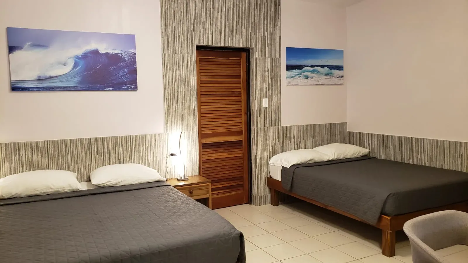 Habitación Ocean Mist con dos camas, una obra de arte con olas y colores neutros.