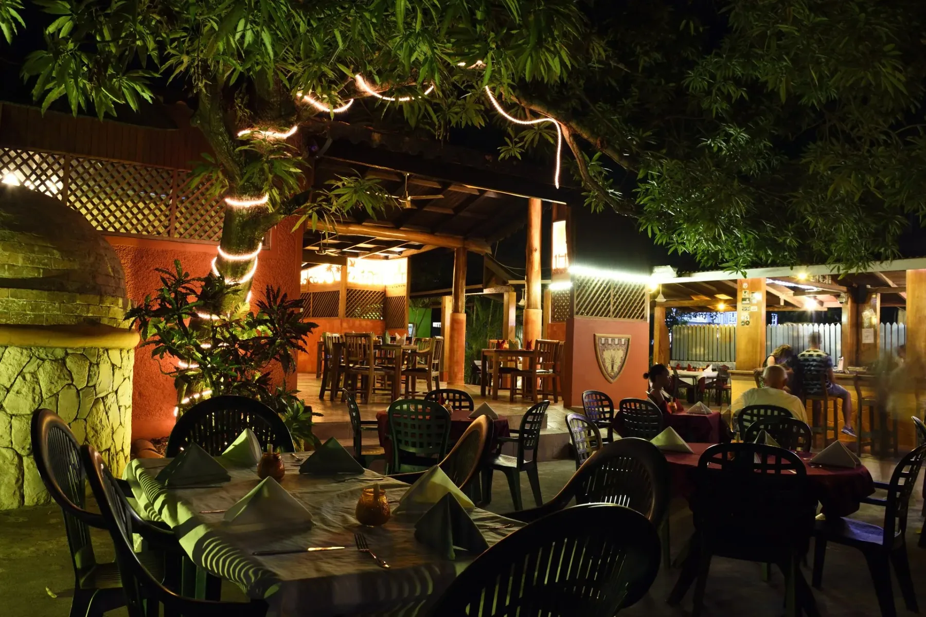 Zona de mesas al aire libre del restaurante por la noche.