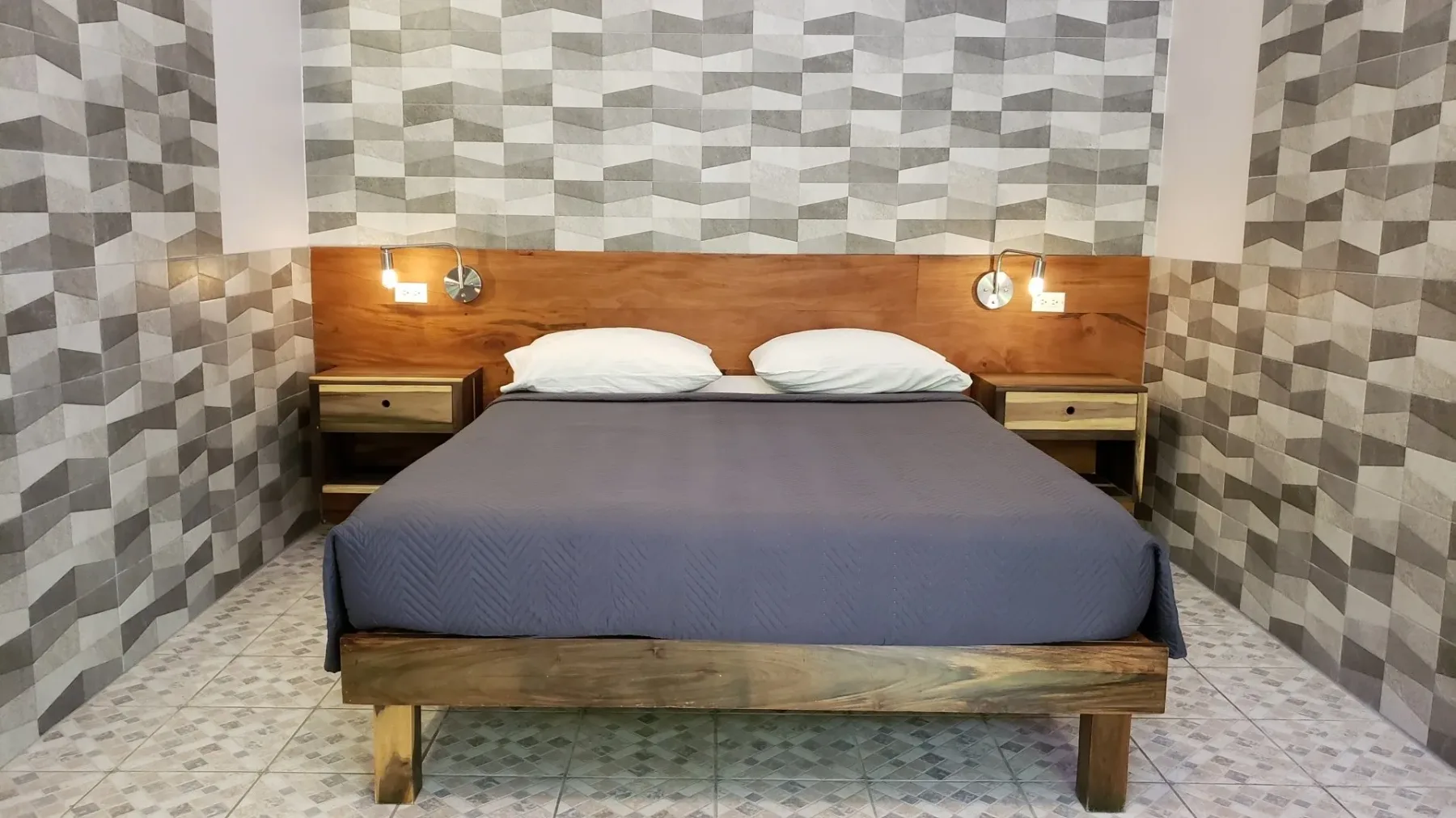 Habitación Pop-Style con estructura de cama de madera y papel tapiz estampado.