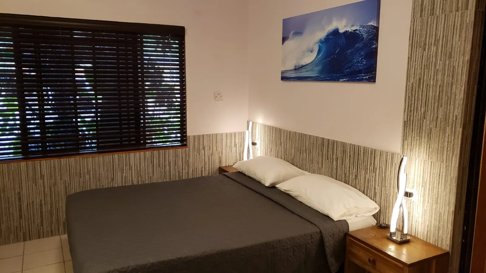 Dormitorio de Ocean Mist con cama y una obra de arte con olas.