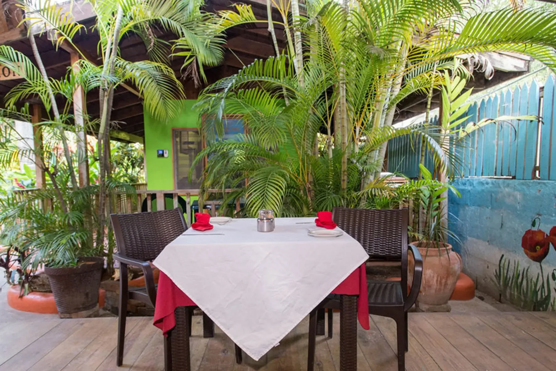 Mesa del restaurante al aire libre bajo vegetación y una estructura de madera.
