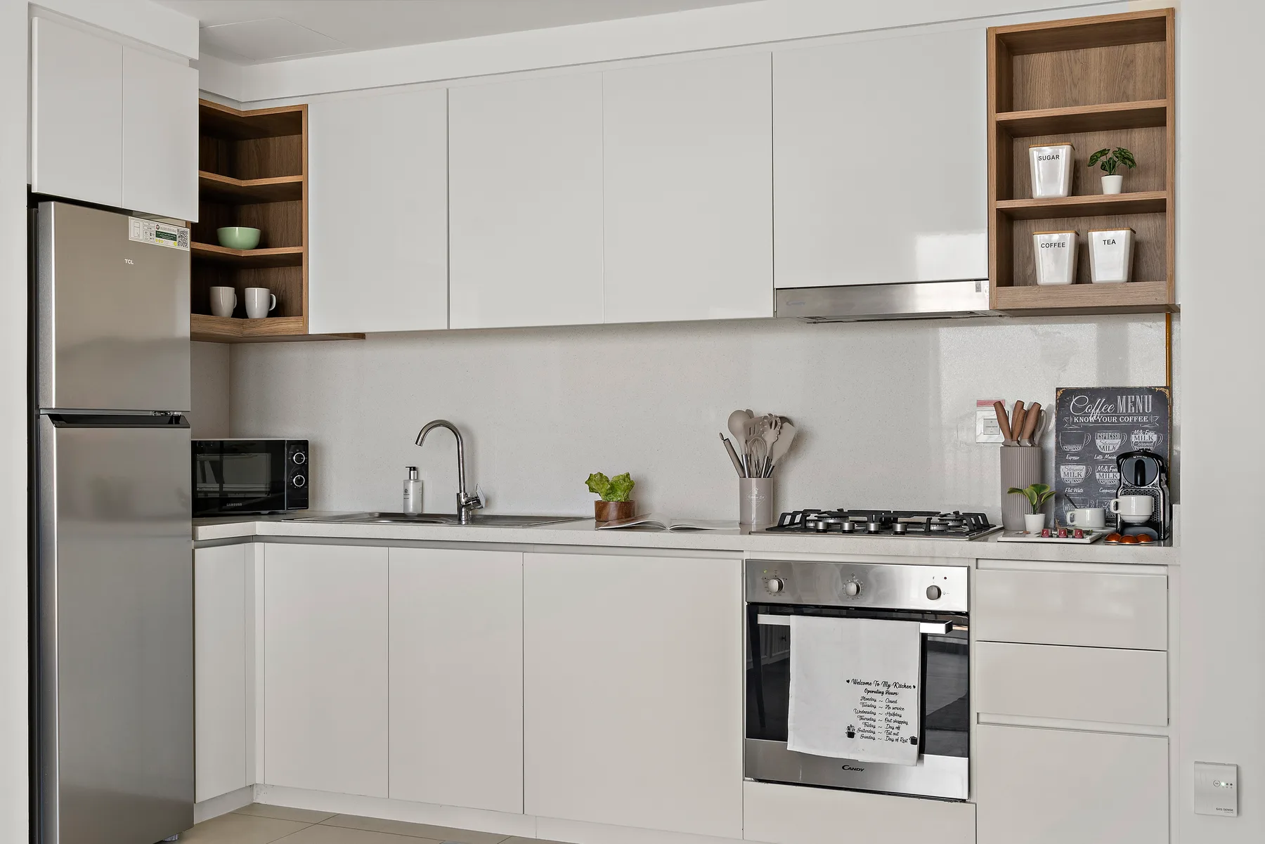 A modern kitchen with white cabinets, a refrigerator, and a cooktop.