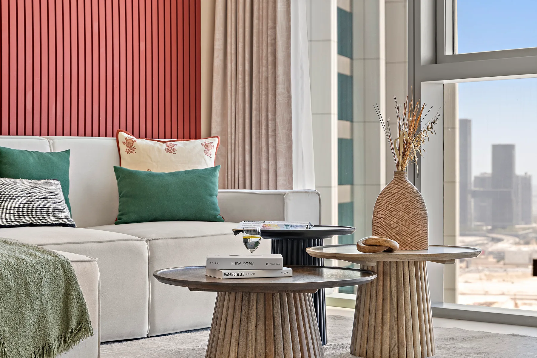 A living room seating area with a light sofa and round coffee tables.