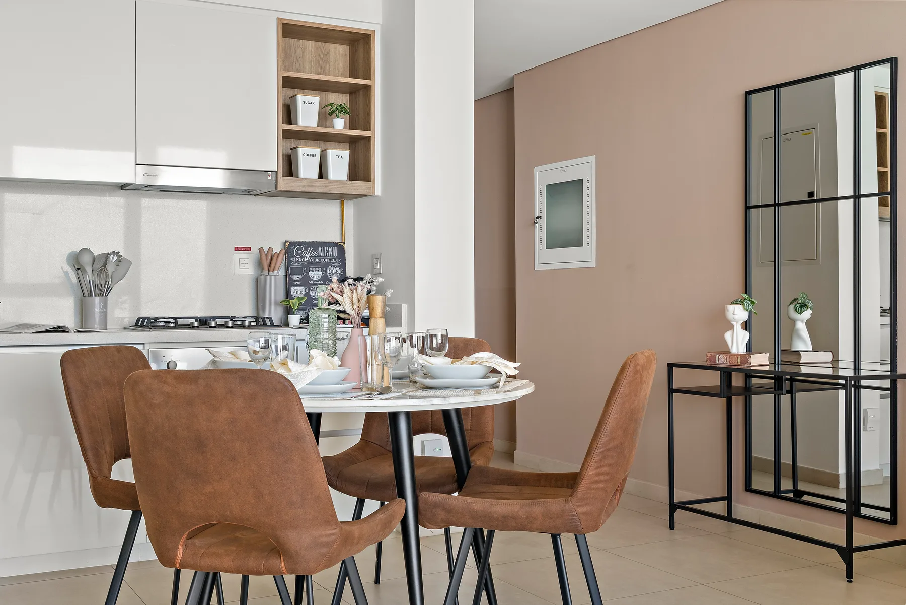 A dining area with a set table beside a modern kitchen.