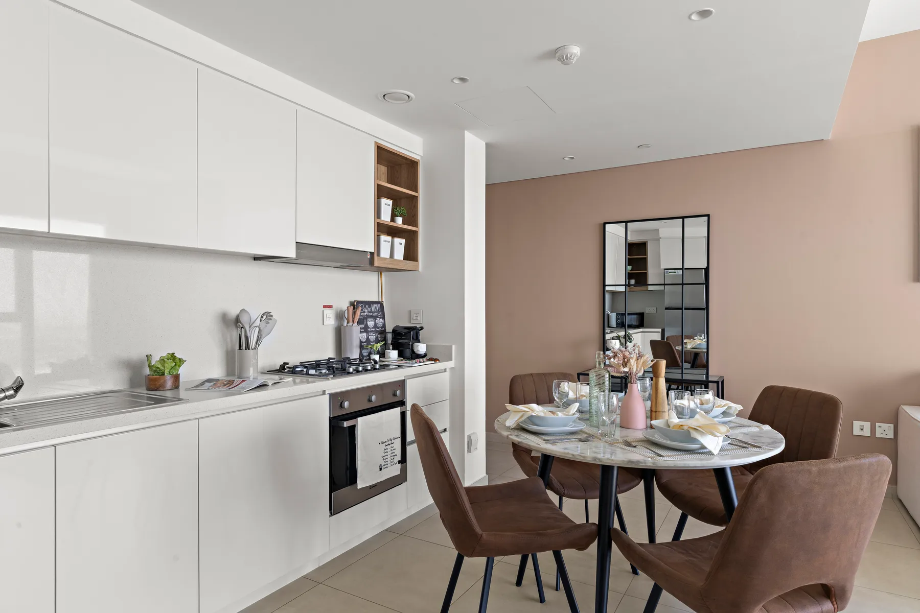 A modern kitchen and dining area with a set dining table.