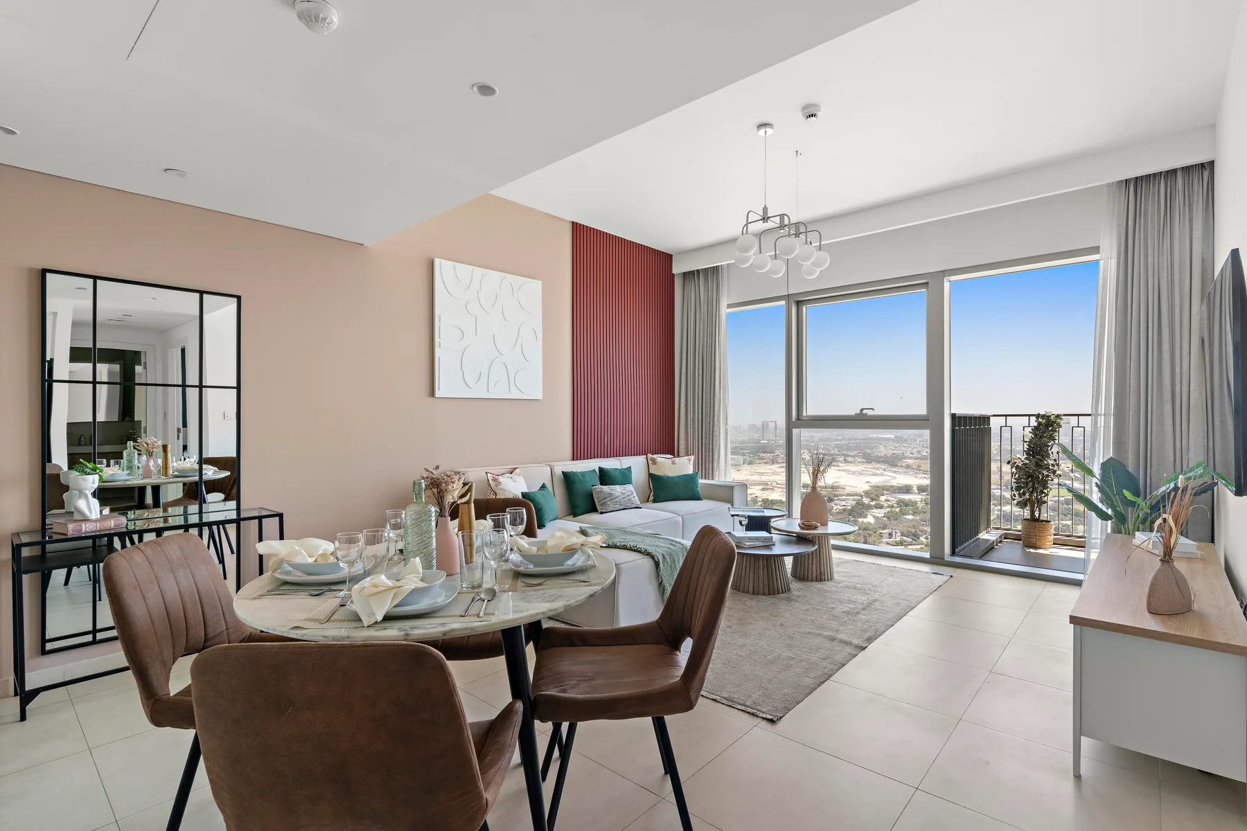 A bright living and dining area with a table beside floor-to-ceiling windows.