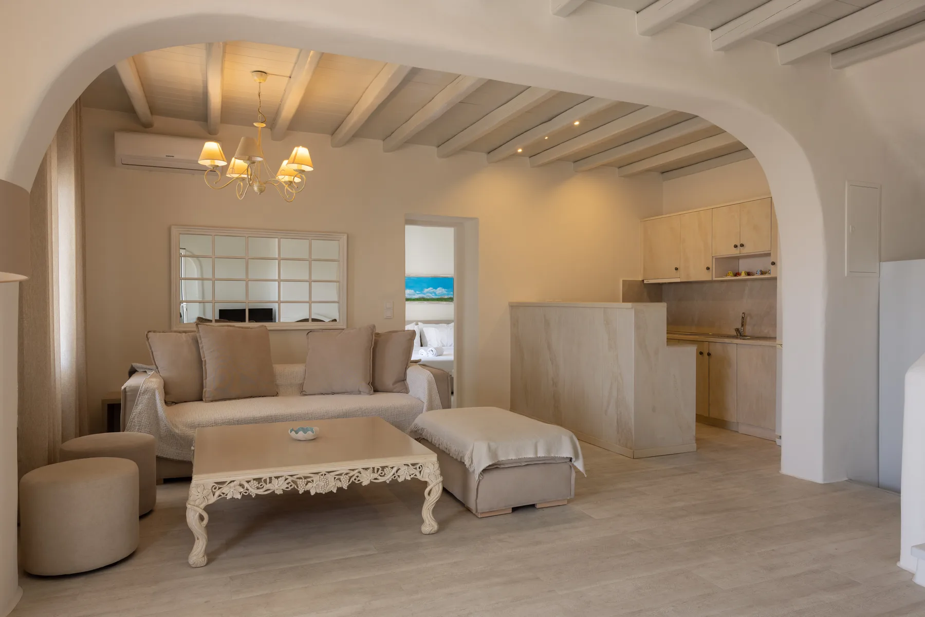 A living area with a sofa, coffee table, and adjoining kitchen.