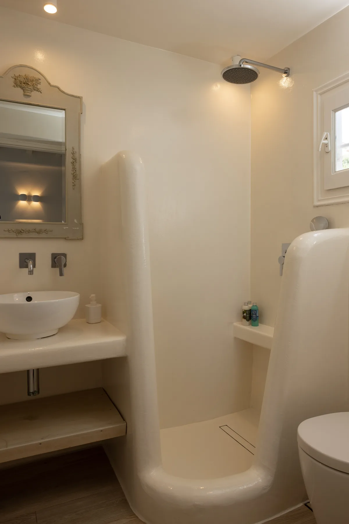 A bathroom with a sink, mirror, and shower.