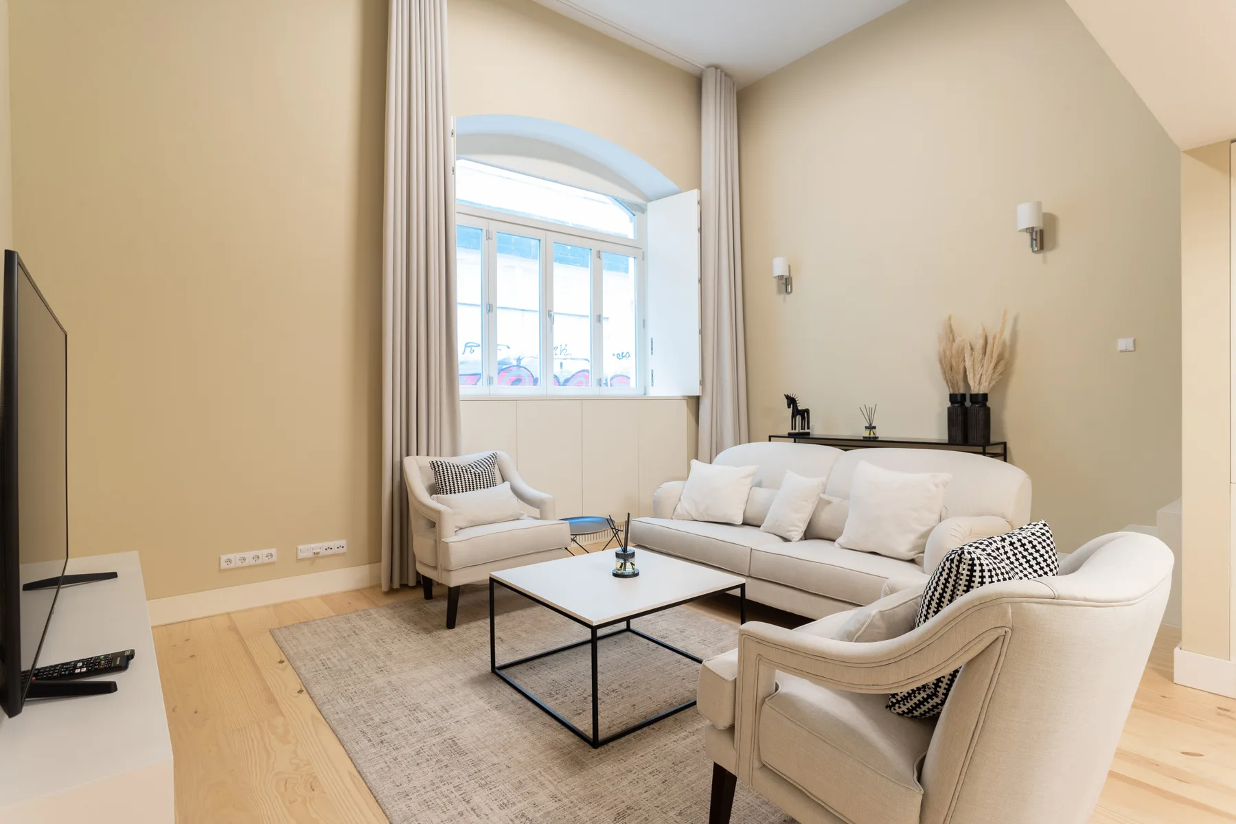 A bright living room with a sofa, armchairs, and a coffee table.