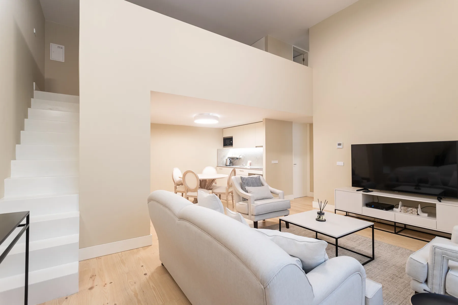 A bright living room with seating, a coffee table, and a television.