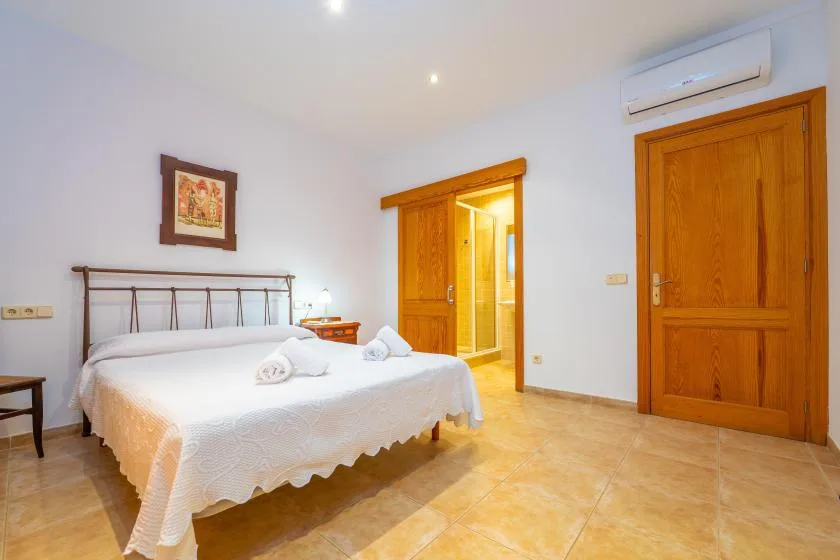 A bedroom with a double bed and wooden doors.