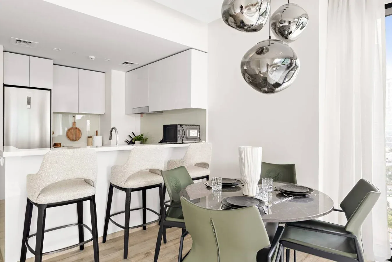 Una cocina y comedor luminosos con una barra y una mesa.