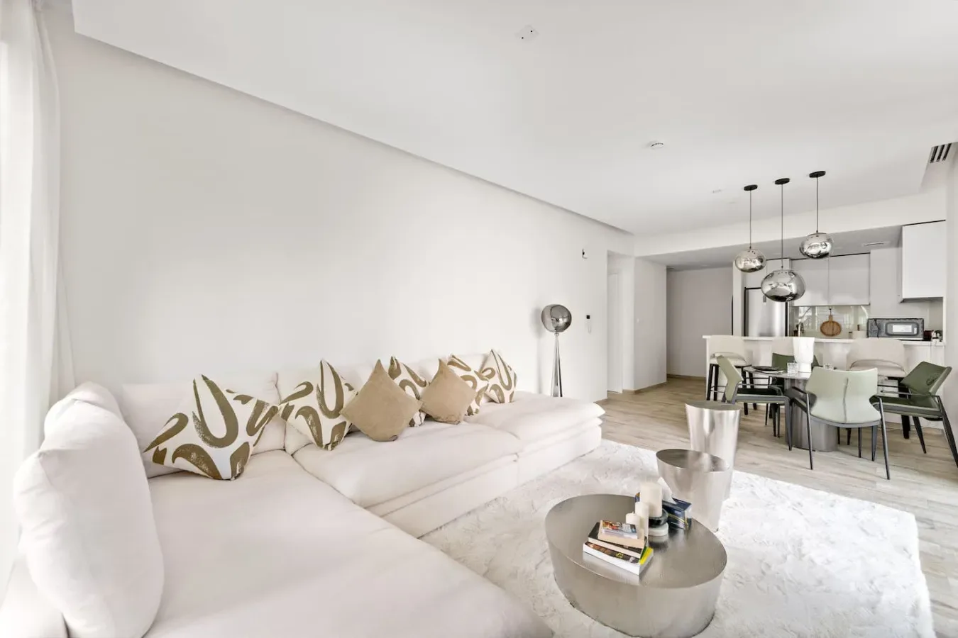 Una sala luminosa con asientos, una mesa de centro y un comedor.
