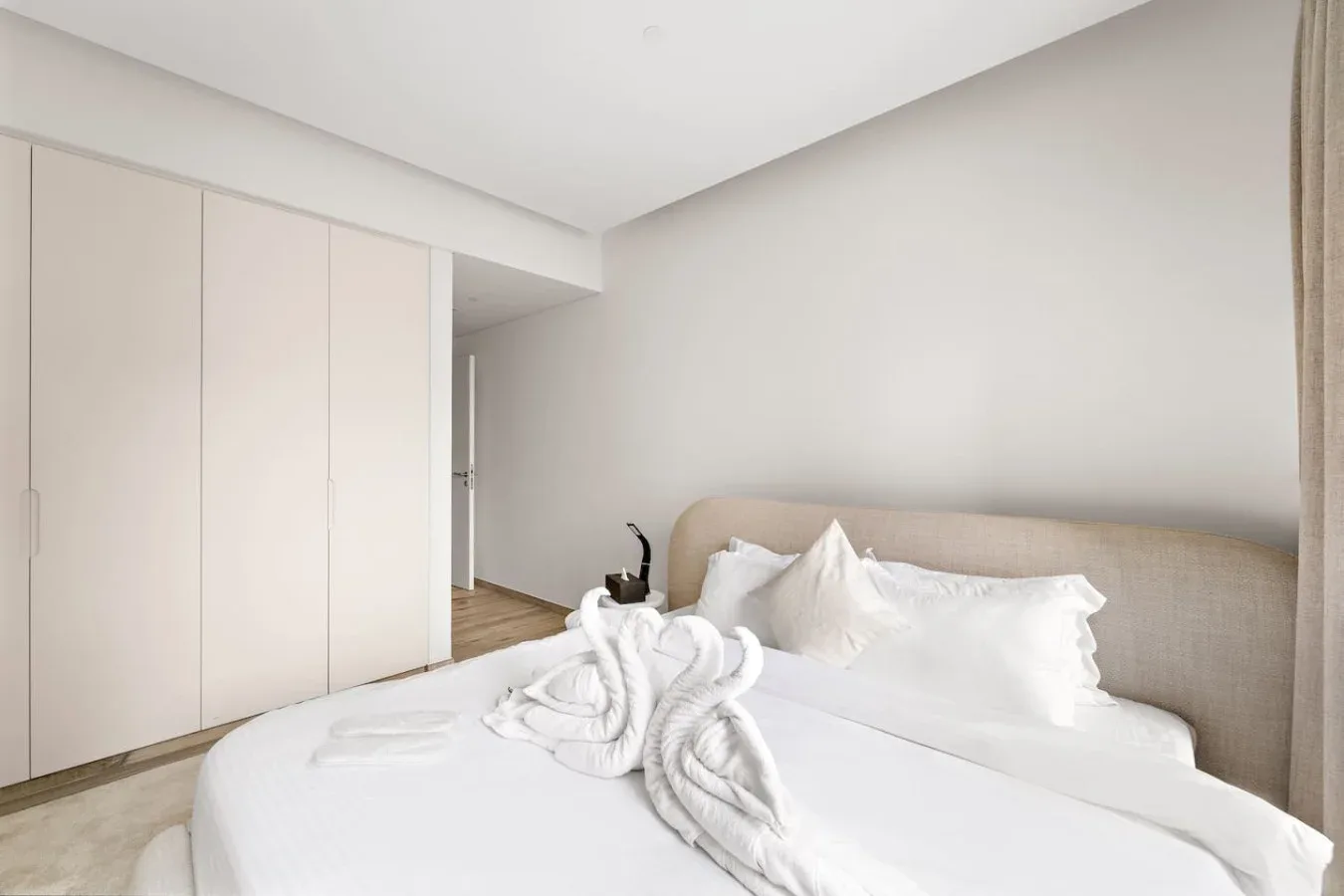Un dormitorio luminoso con una cama bien hecha y armarios empotrados.