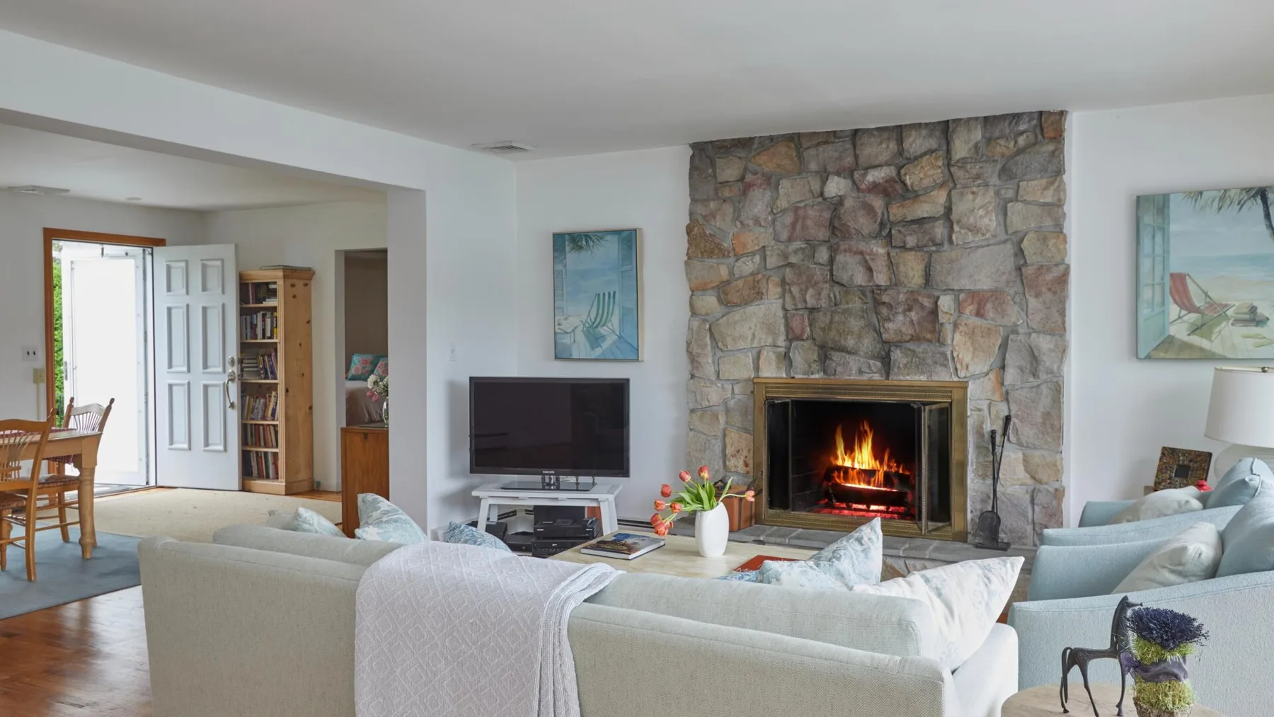 Una sala de estar con asientos dispuestos alrededor de una chimenea y un televisor.