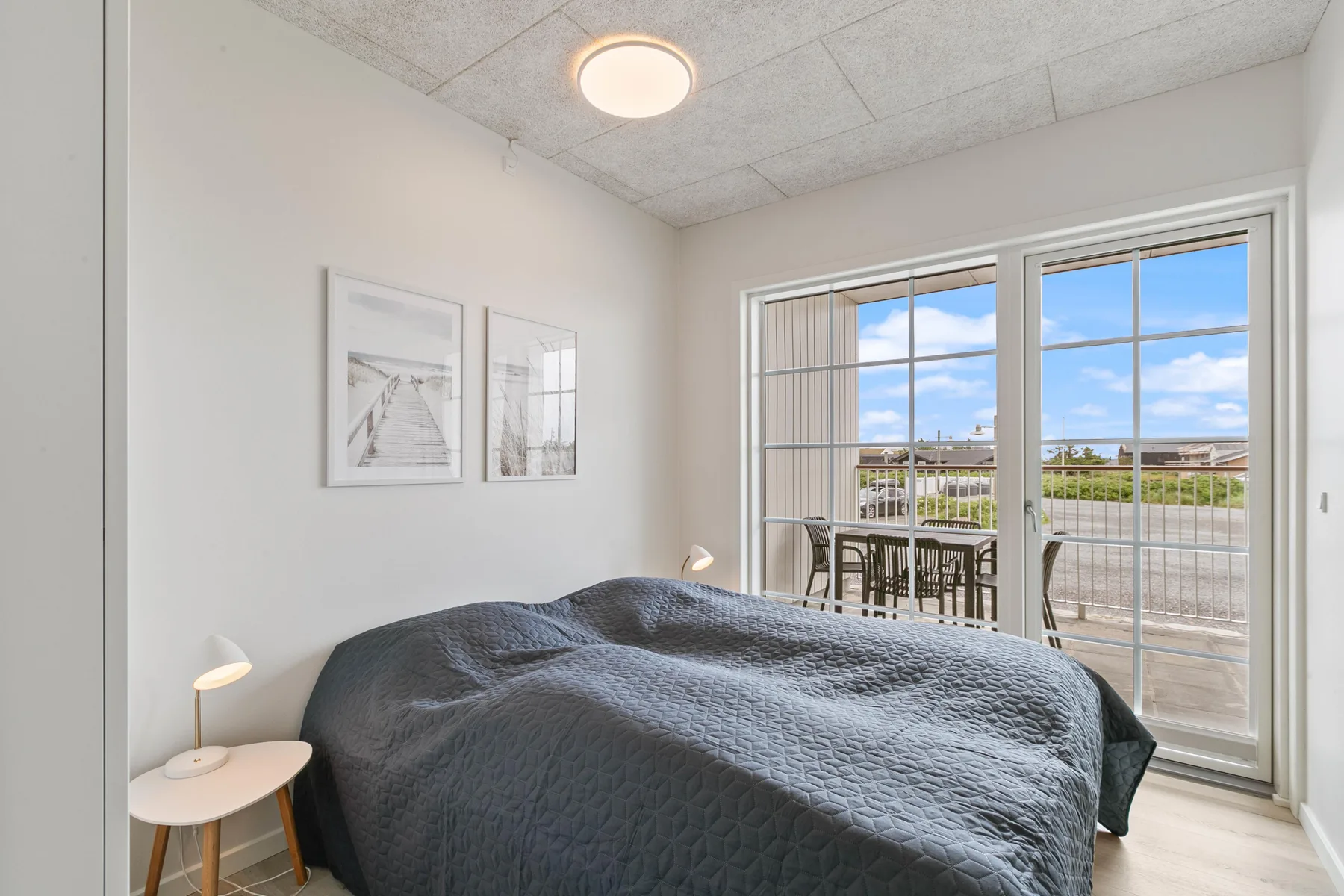 Un dormitorio con una cama junto a puertas de cristal que dan a un patio.