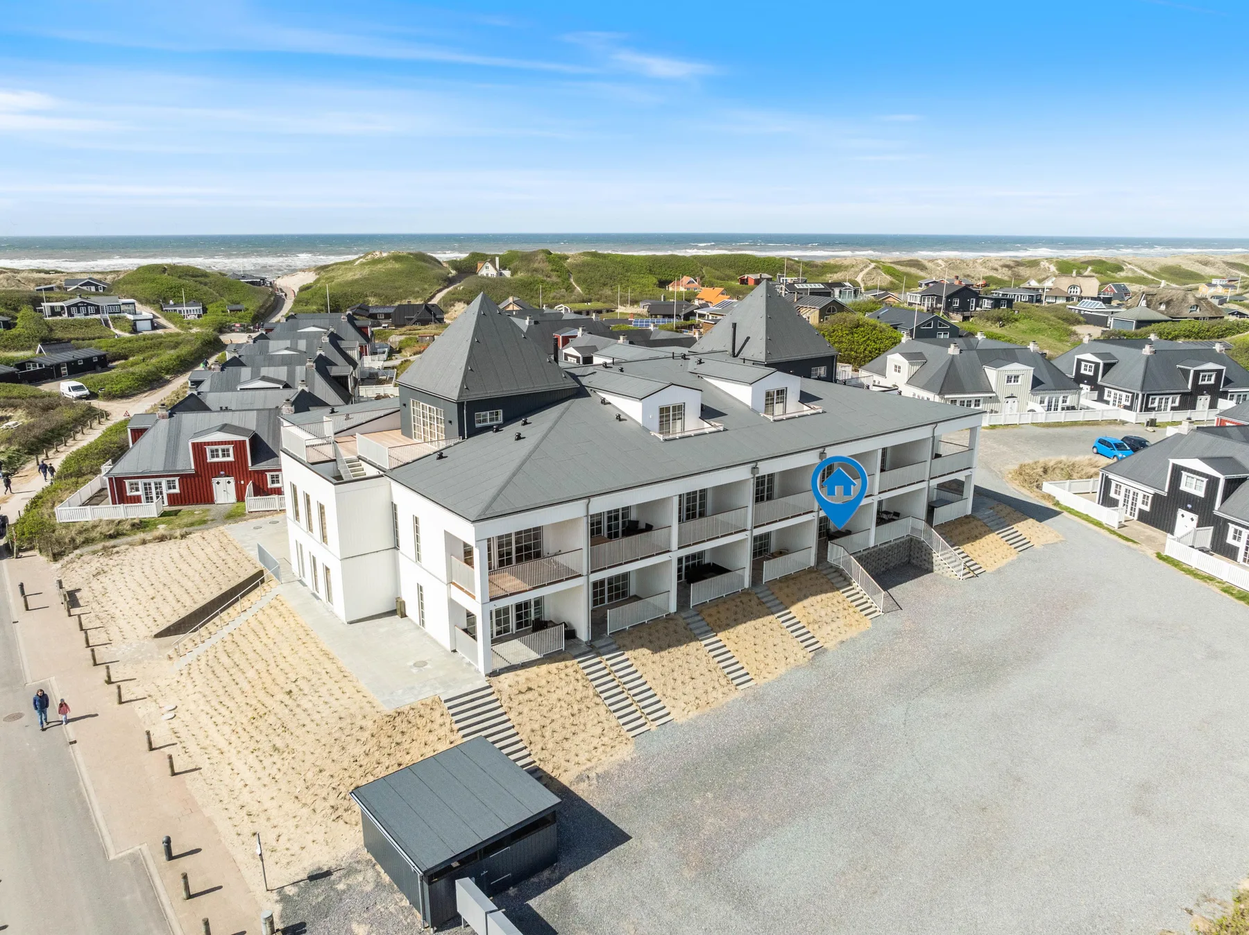 Vista aérea de una hilera de edificios modernos junto a una playa de arena.