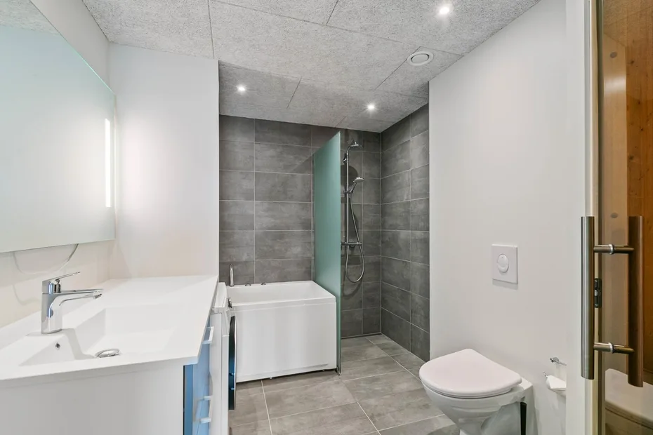 Un baño moderno con bañera, ducha, lavabo e inodoro.