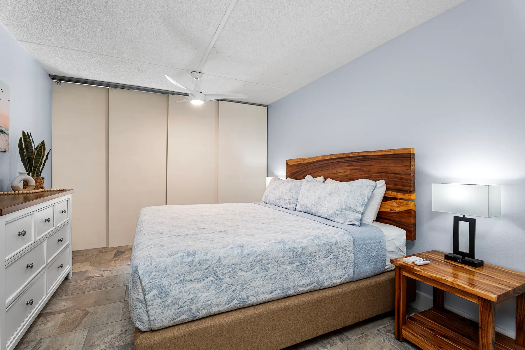 Un dormitorio con una cama, un cabecero de madera y una mesita de noche.