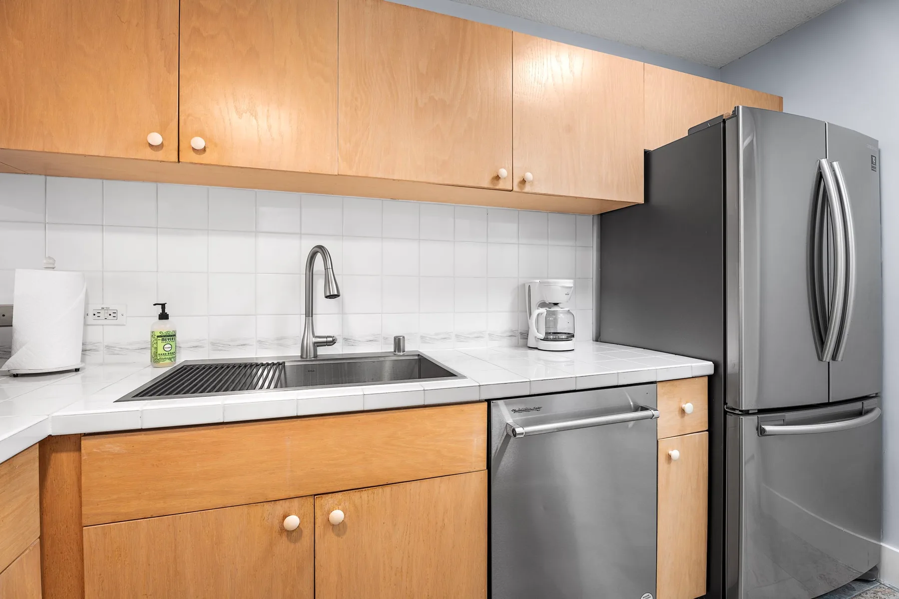 Una cocina con fregadero, encimera y electrodomésticos de acero inoxidable.