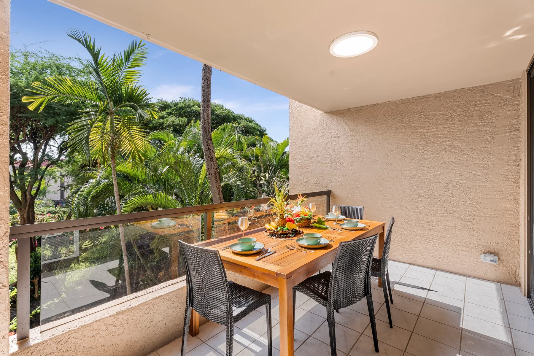 Comedor exterior cubierto con una mesa y asientos frente a la vegetación.