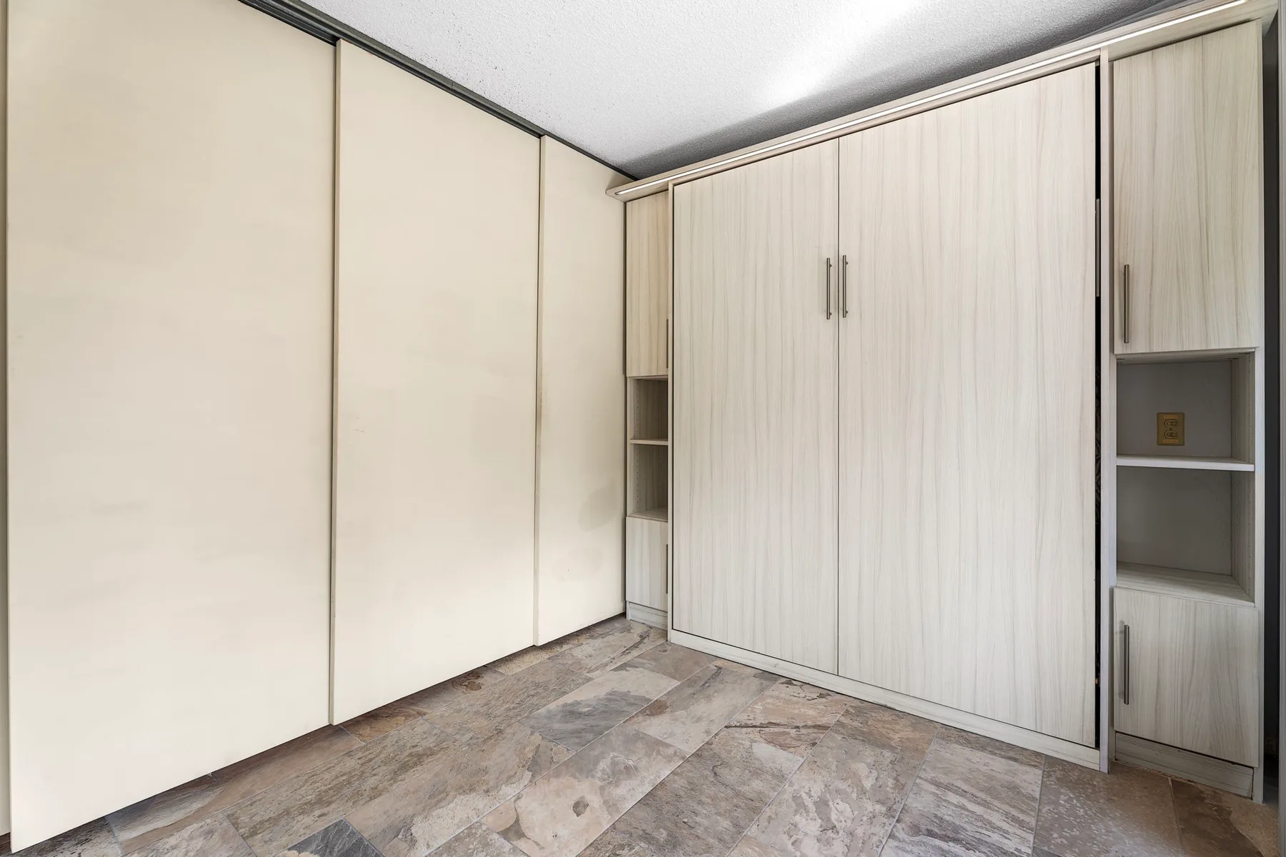 Habitación con armarios empotrados y un suelo estampado.