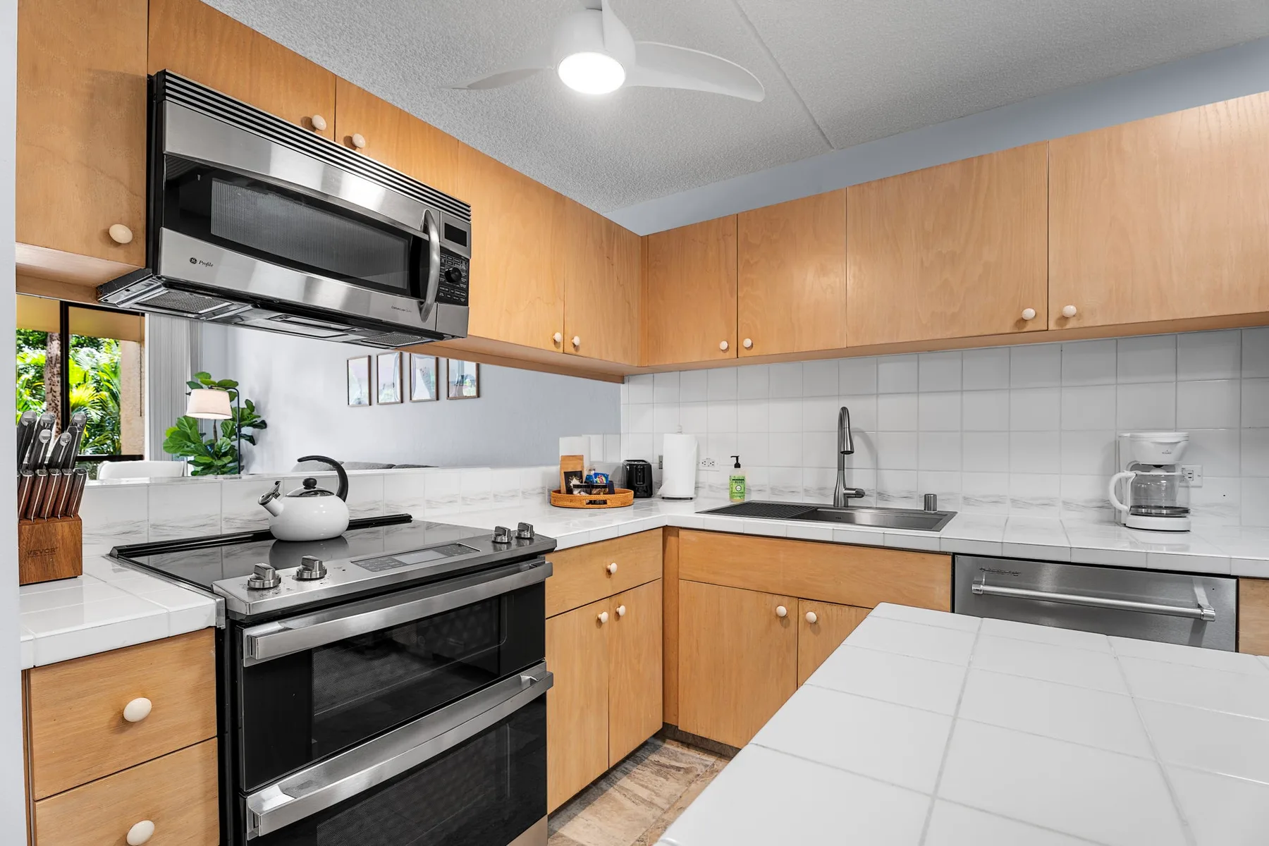 Una cocina con gabinetes de madera, una estufa y un fregadero.