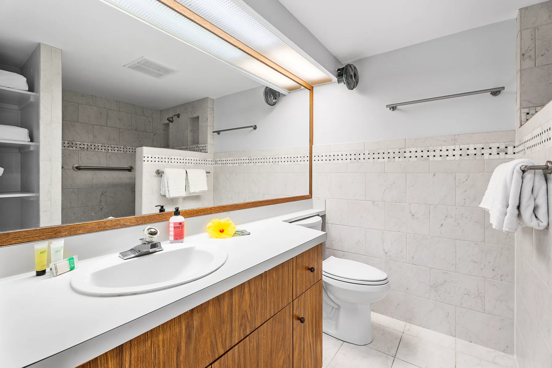 Un baño con lavabo, espejo e inodoro.