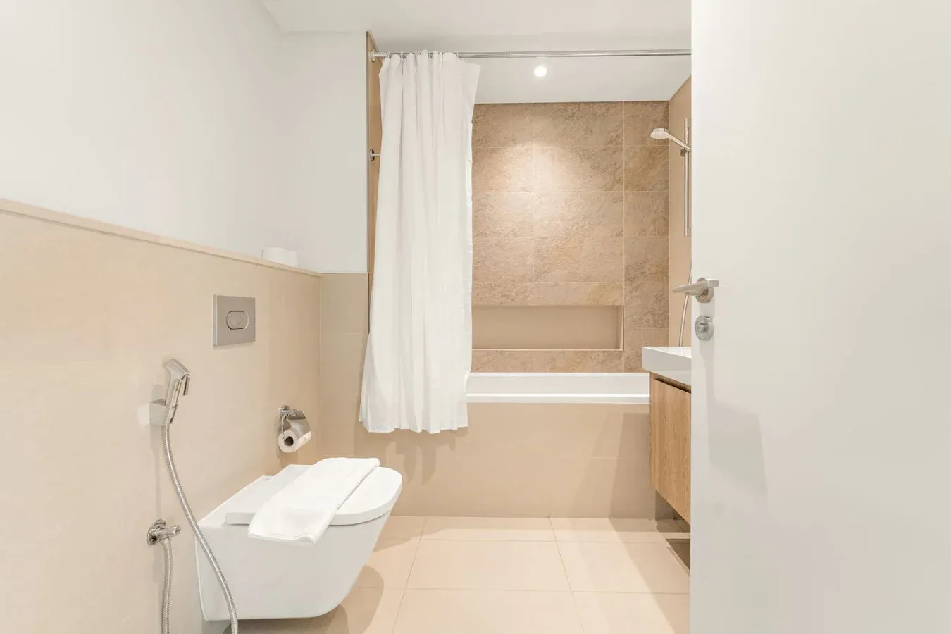 A bathroom with a bathtub, shower curtain, and toilet.