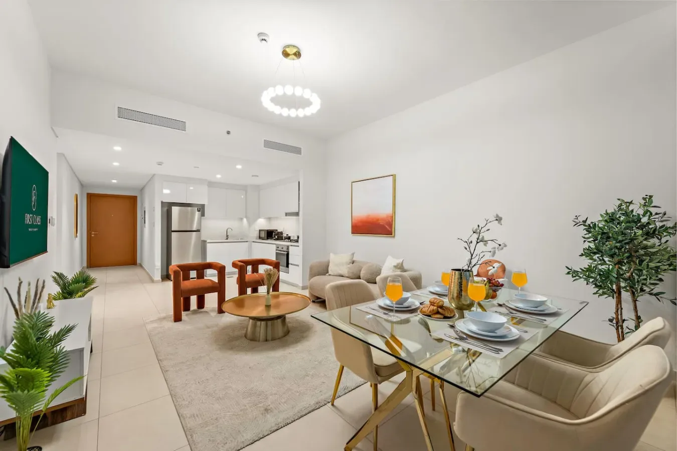 A bright open-plan living and dining area with a glass dining table and seating.