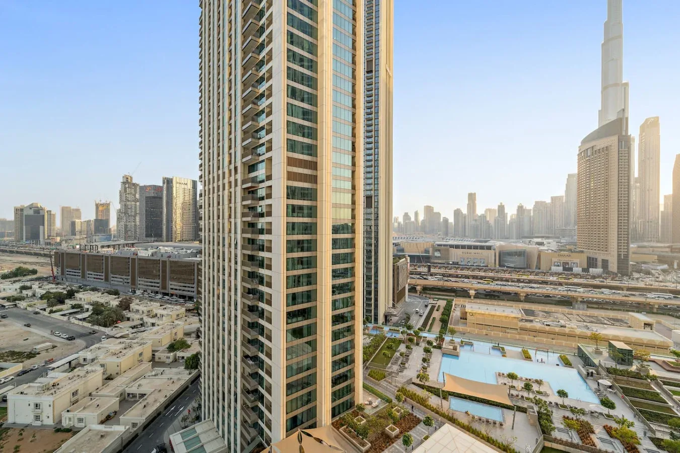 A city skyline view with a tall tower in the foreground and a pool below.