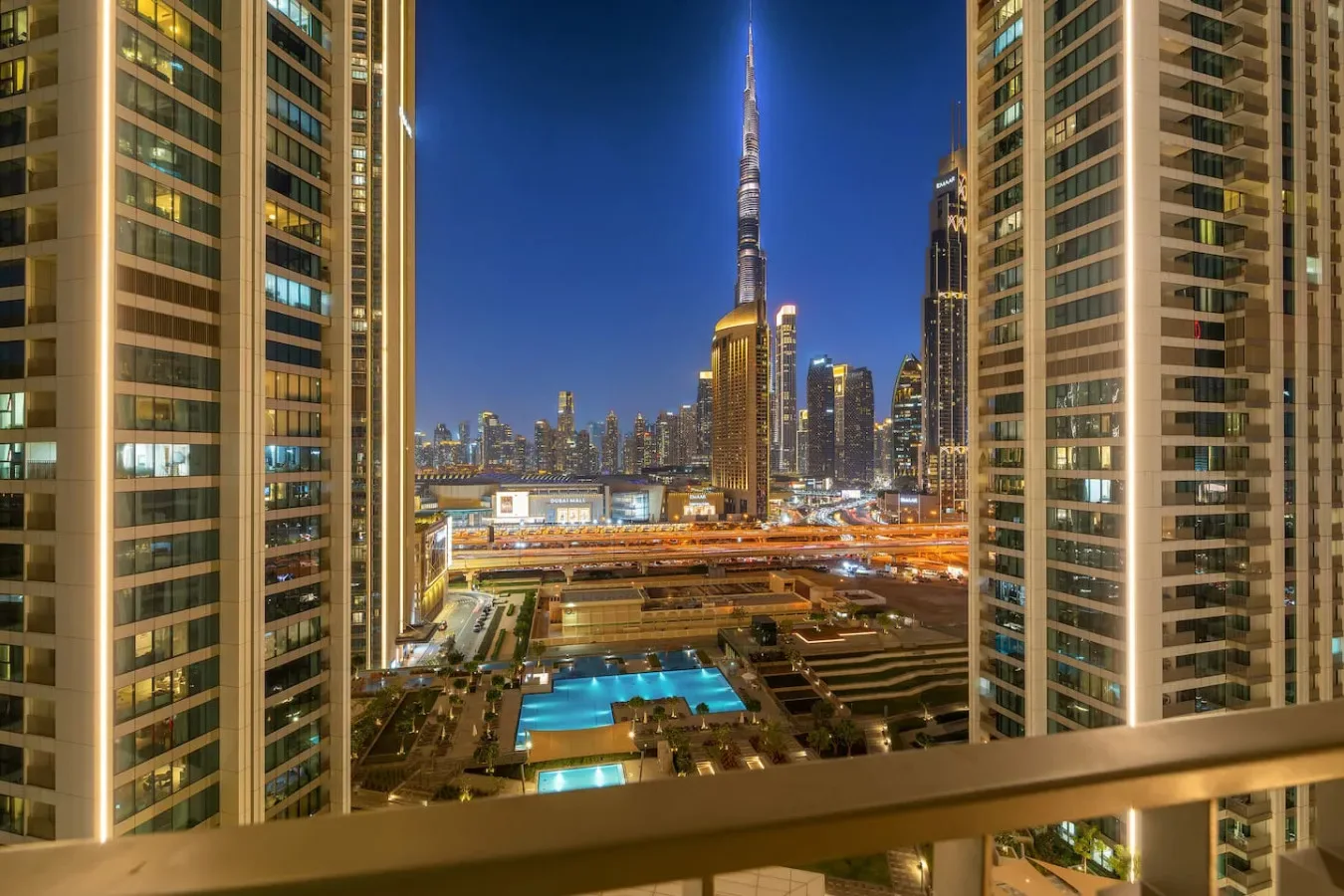 Nighttime city skyline with a tall central tower and illuminated buildings.
