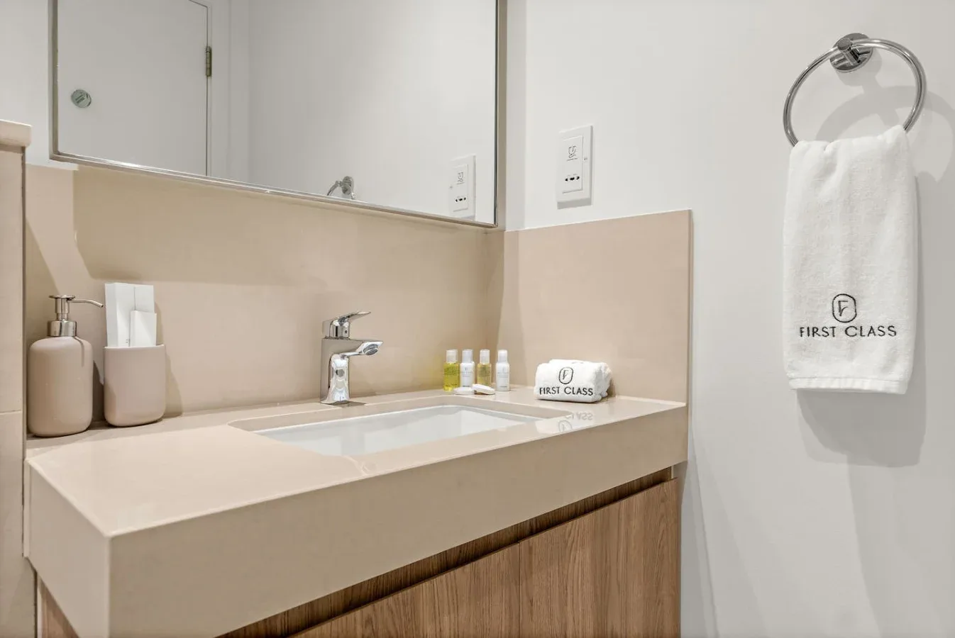 A bathroom vanity with a sink, mirror, and toiletries.