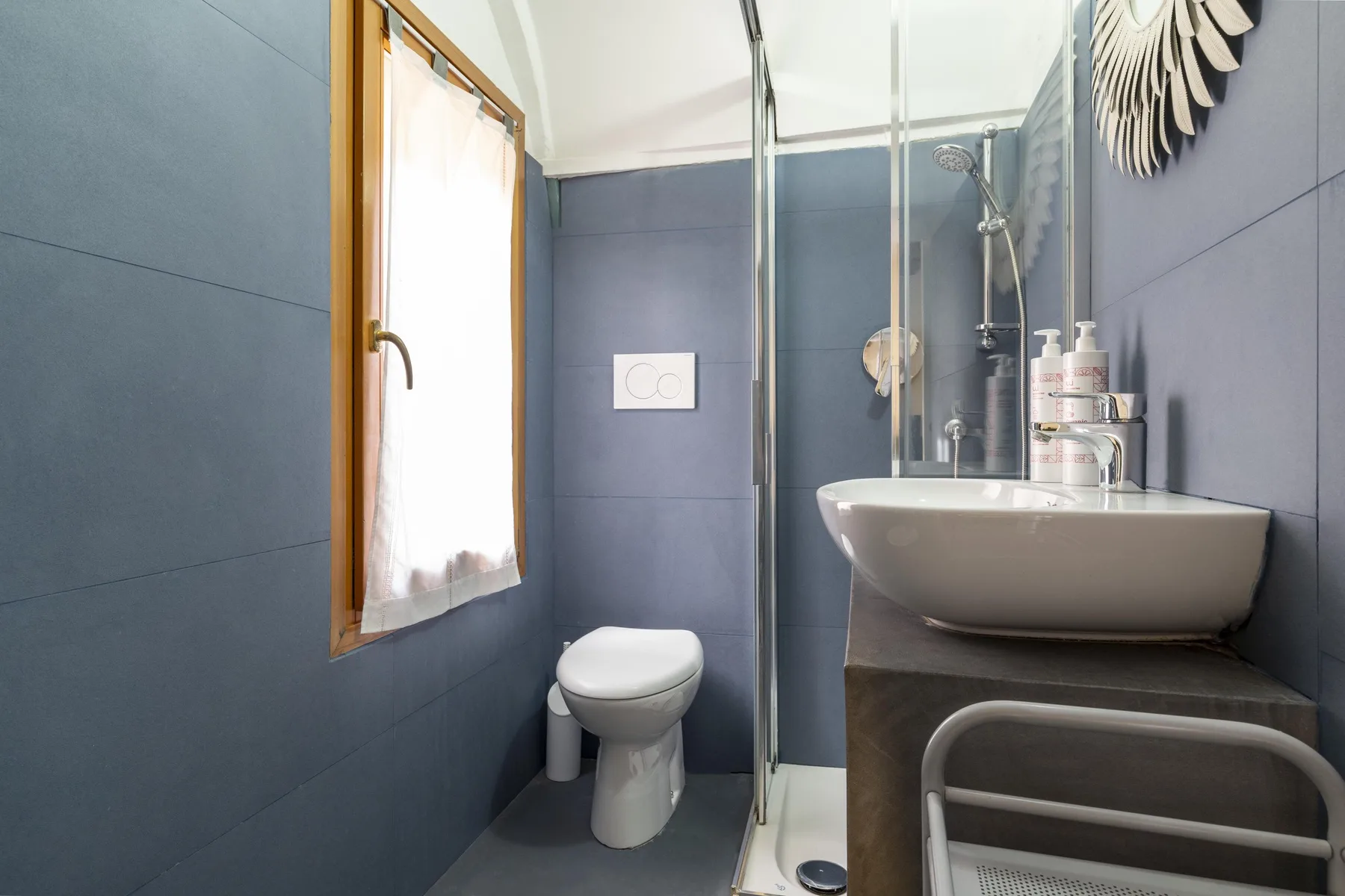 Un baño alicatado con ducha, lavabo e inodoro.