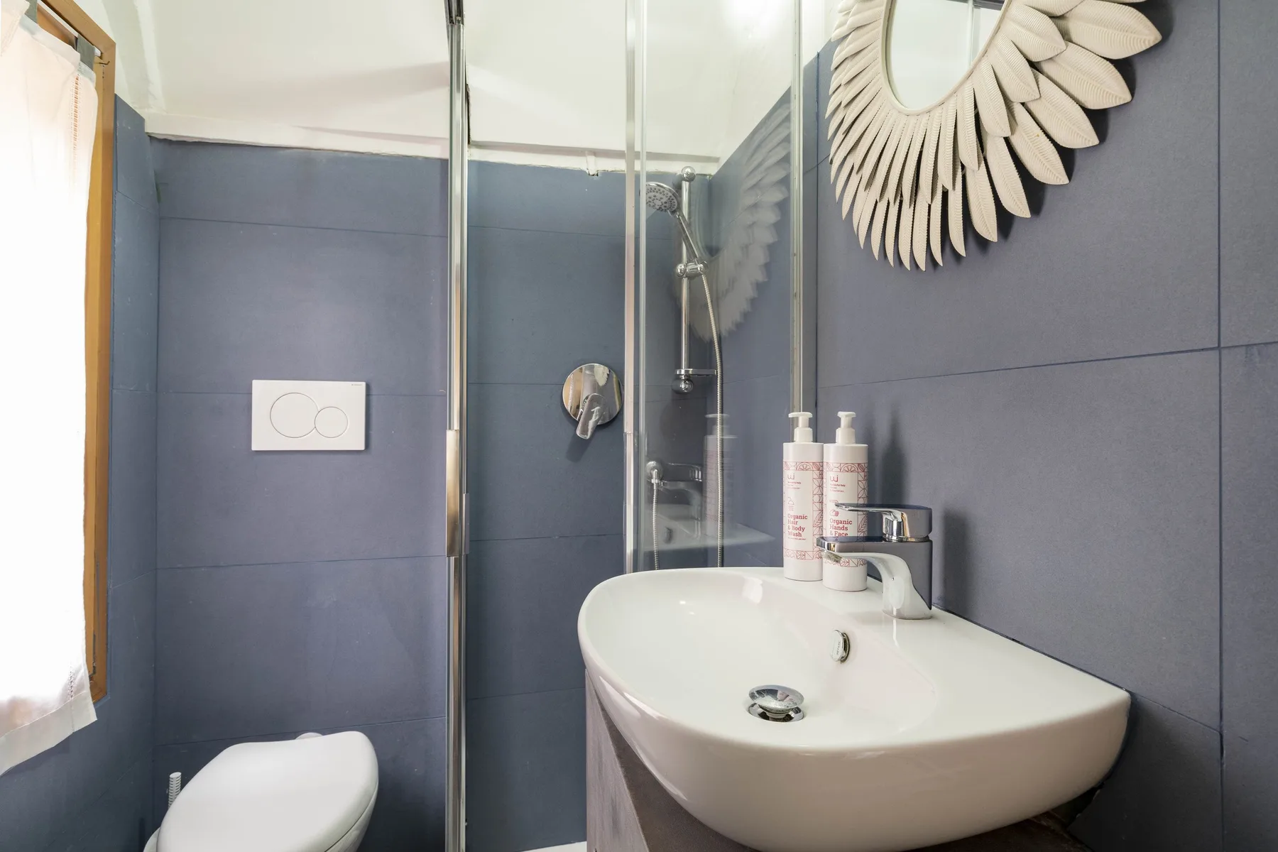 Un baño con lavabo, inodoro y mampara de vidrio.