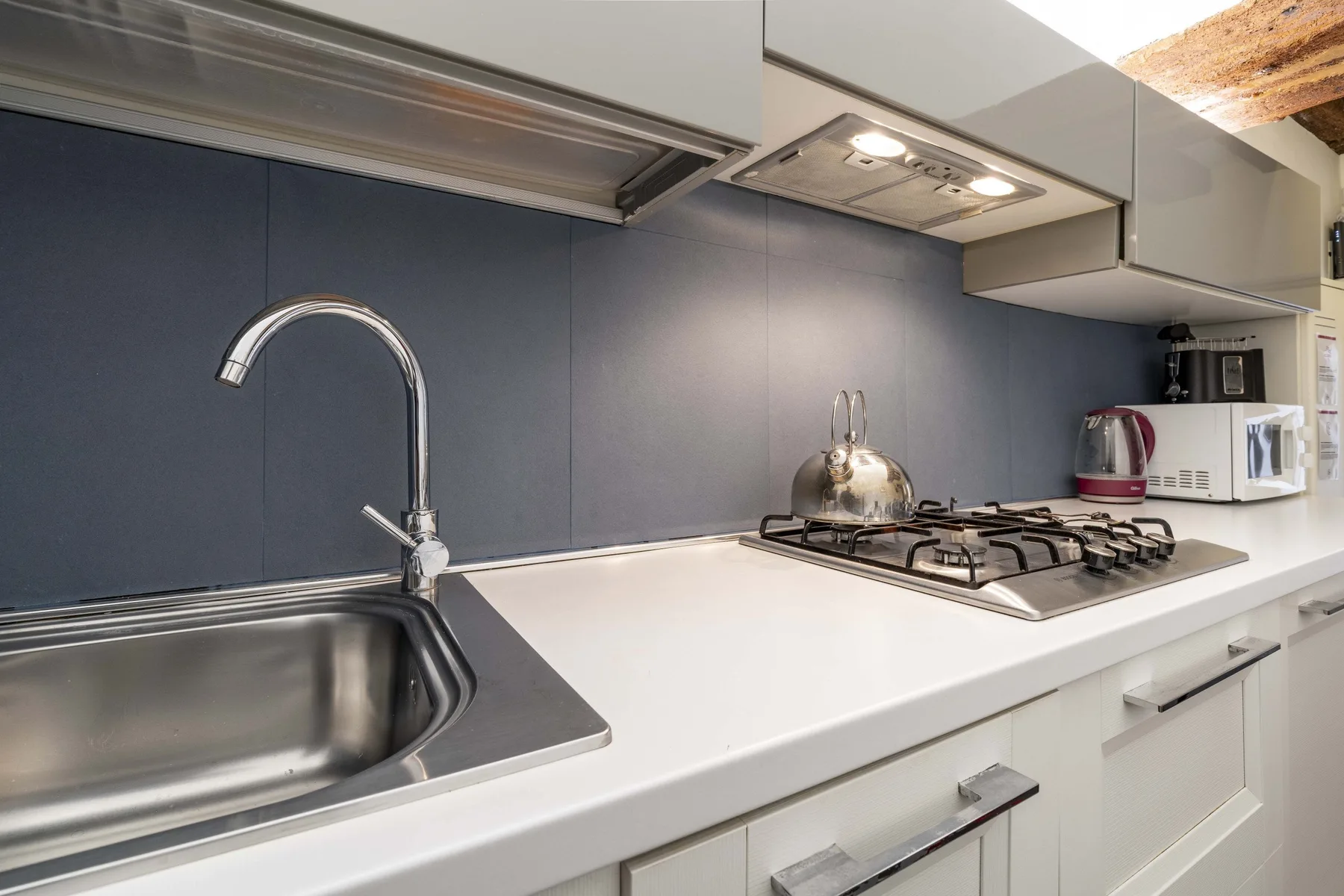 Una cocina moderna con fregadero, encimera y cocina de gas.