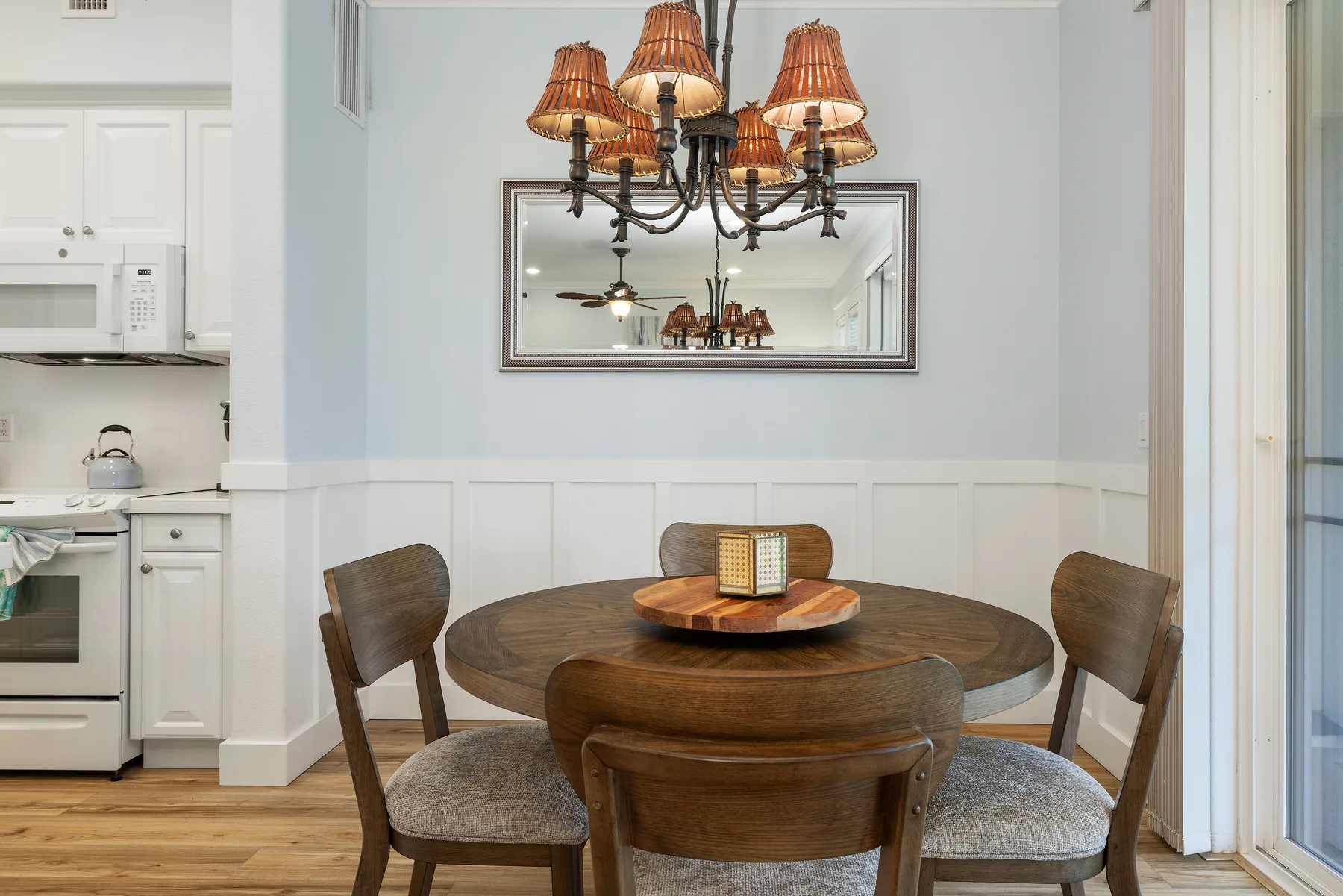 Comedor con una mesa redonda de madera, sillas y una lámpara de techo.
