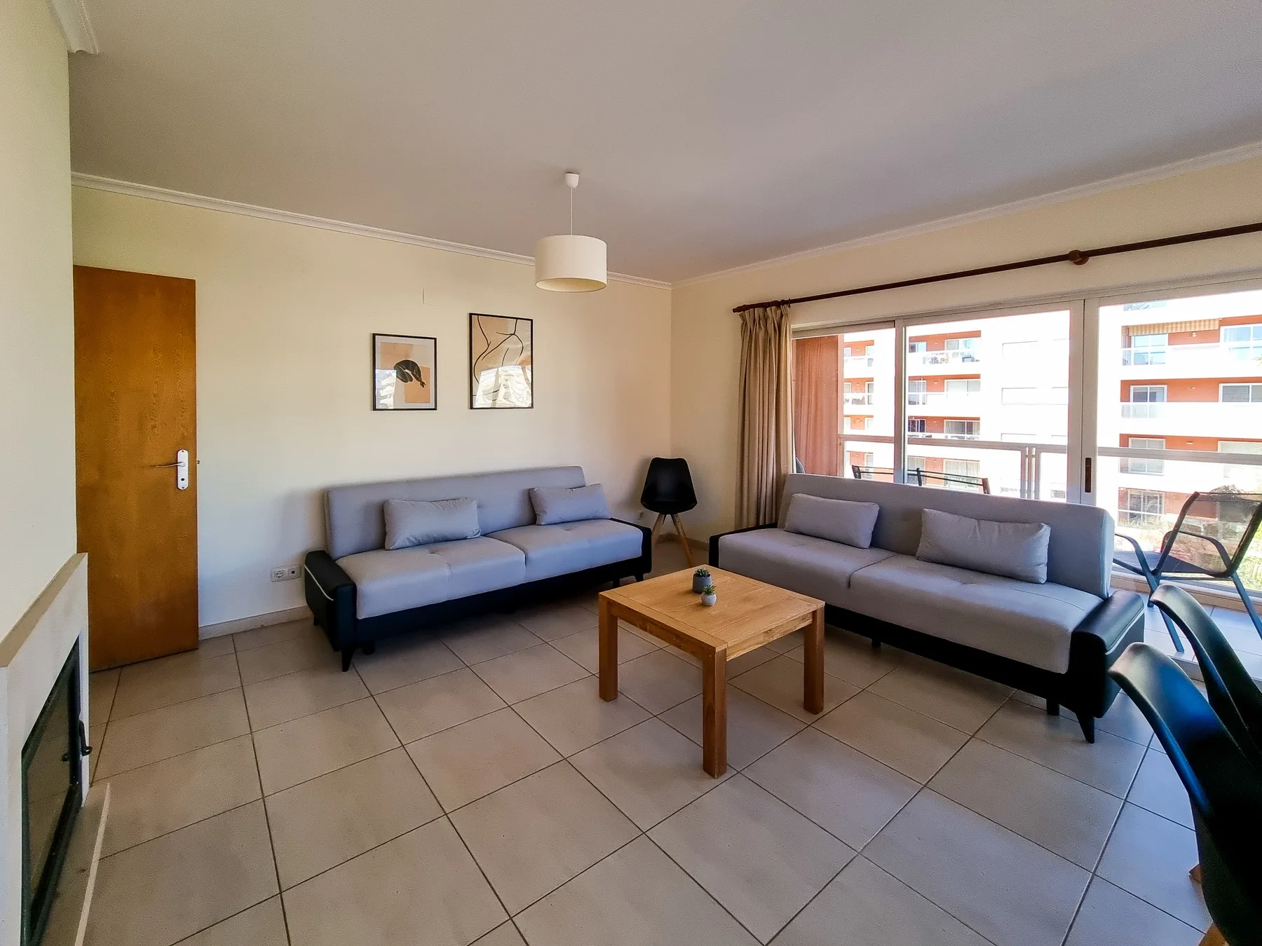 Una sala de estar con dos zonas para sentarse y una mesa de centro de madera.