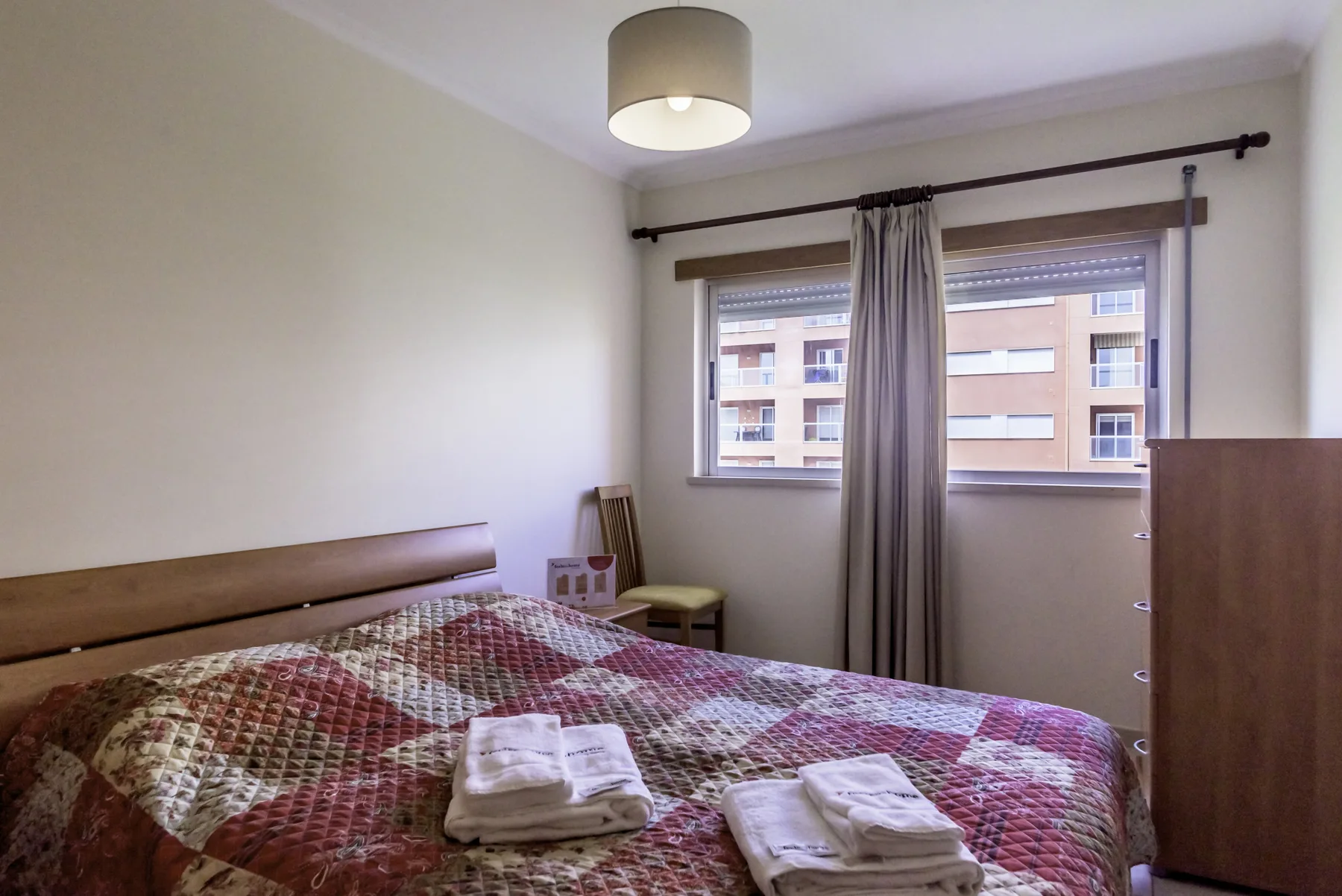 Un dormitorio con una cama doble y una ventana con cortinas.