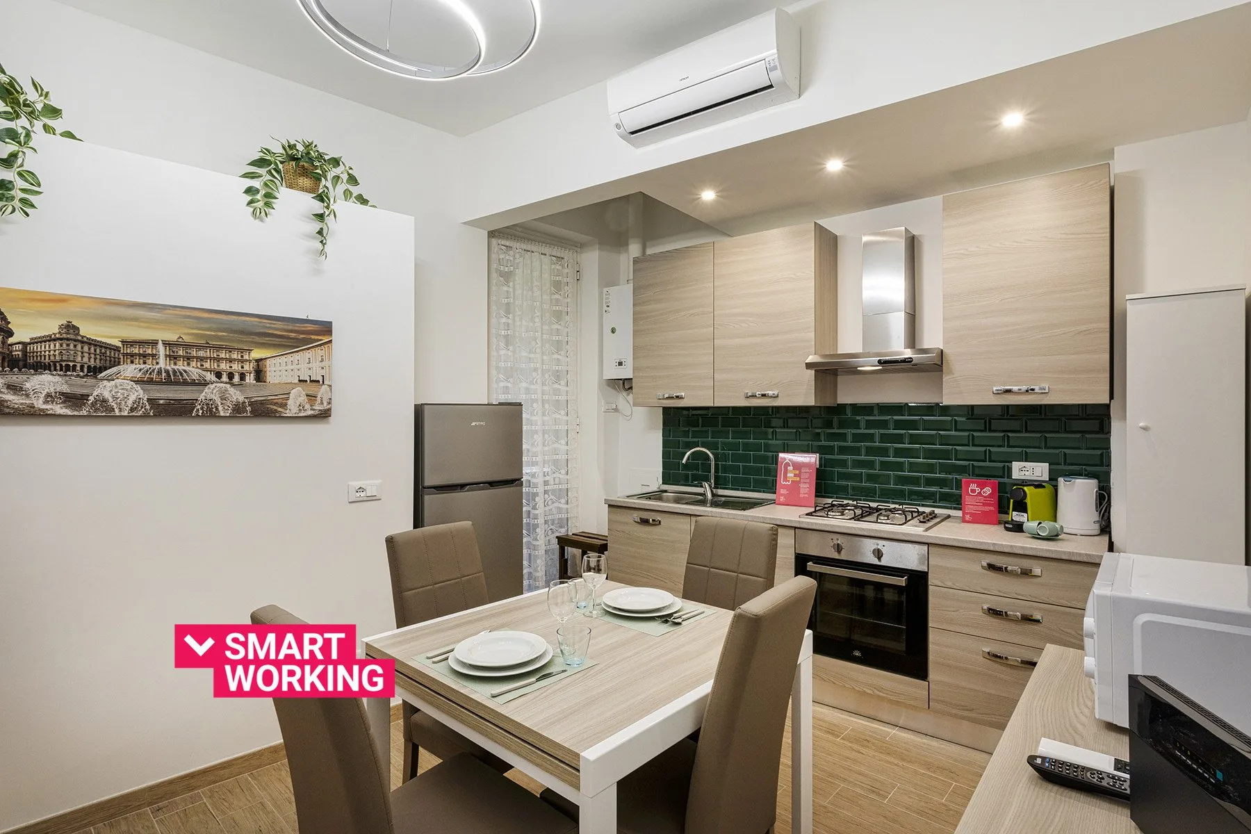 A dining area beside a compact kitchen, with a table set for a meal.