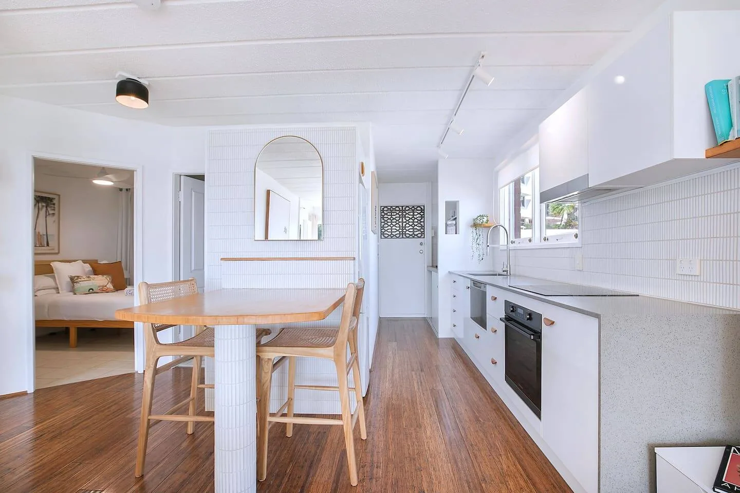 Una cocina luminosa con una mesa de madera y una encimera junto a la pared.