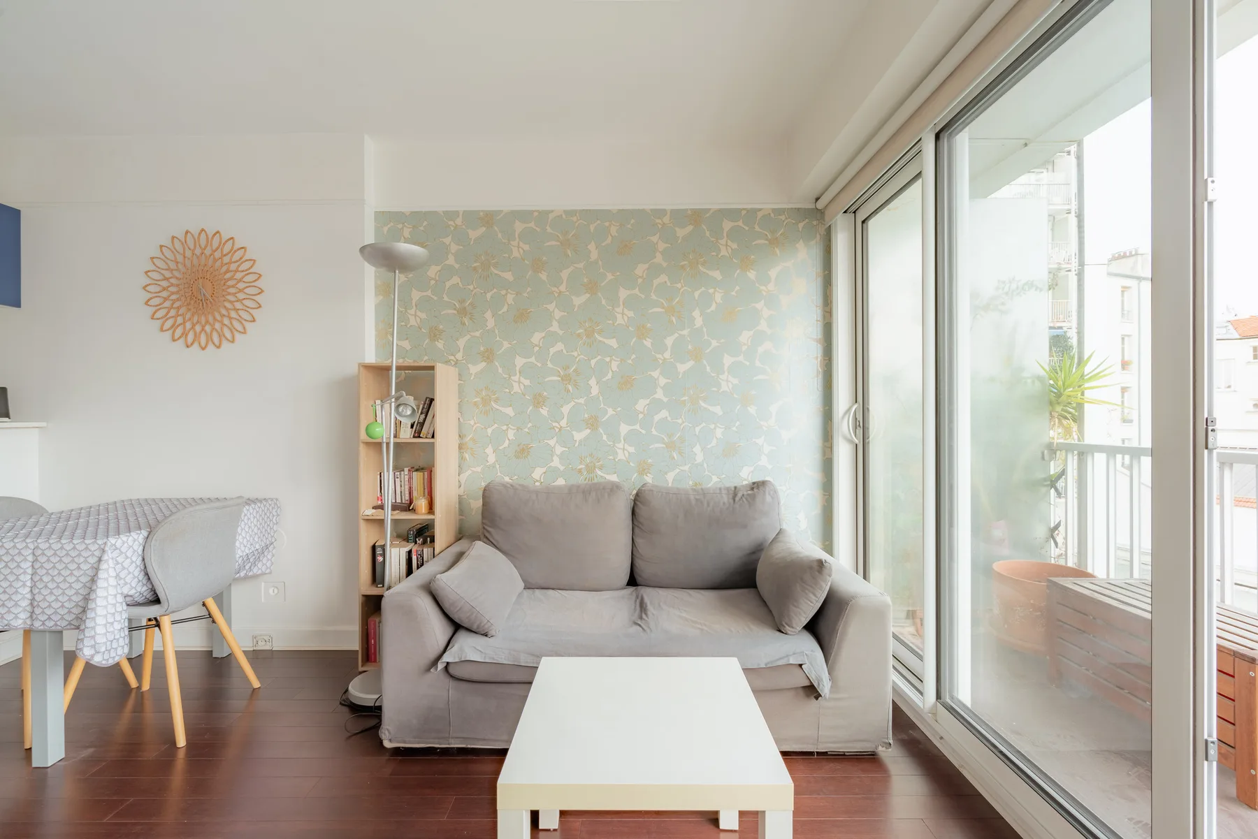 A living room with a sofa, coffee table, and large glass doors.