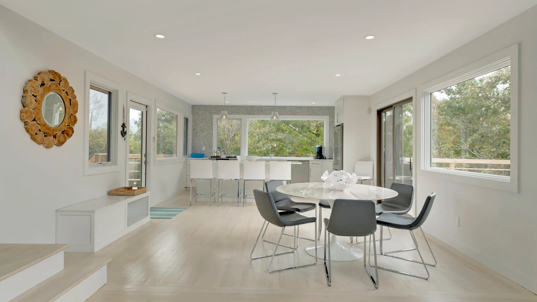 A bright dining area with a round table and large windows.
