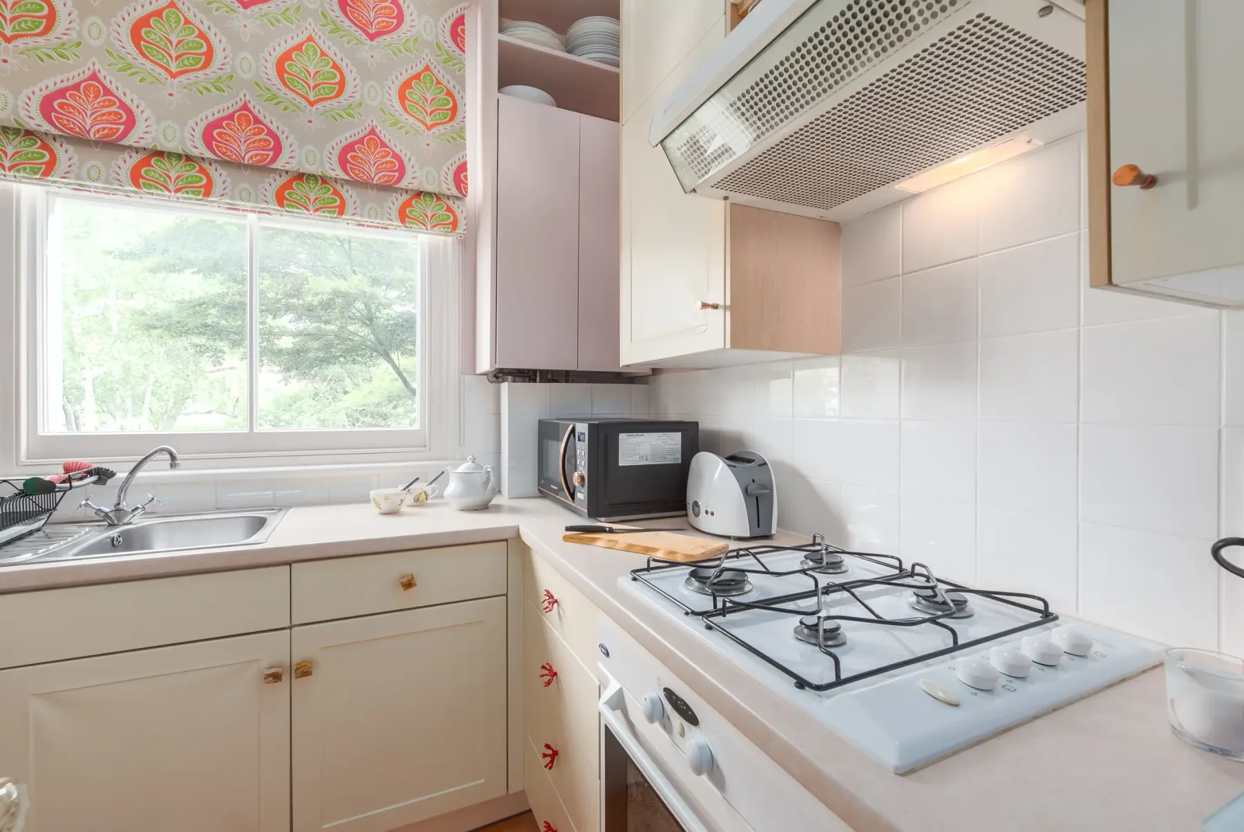 A bright kitchen with a window, countertop, and stovetop.