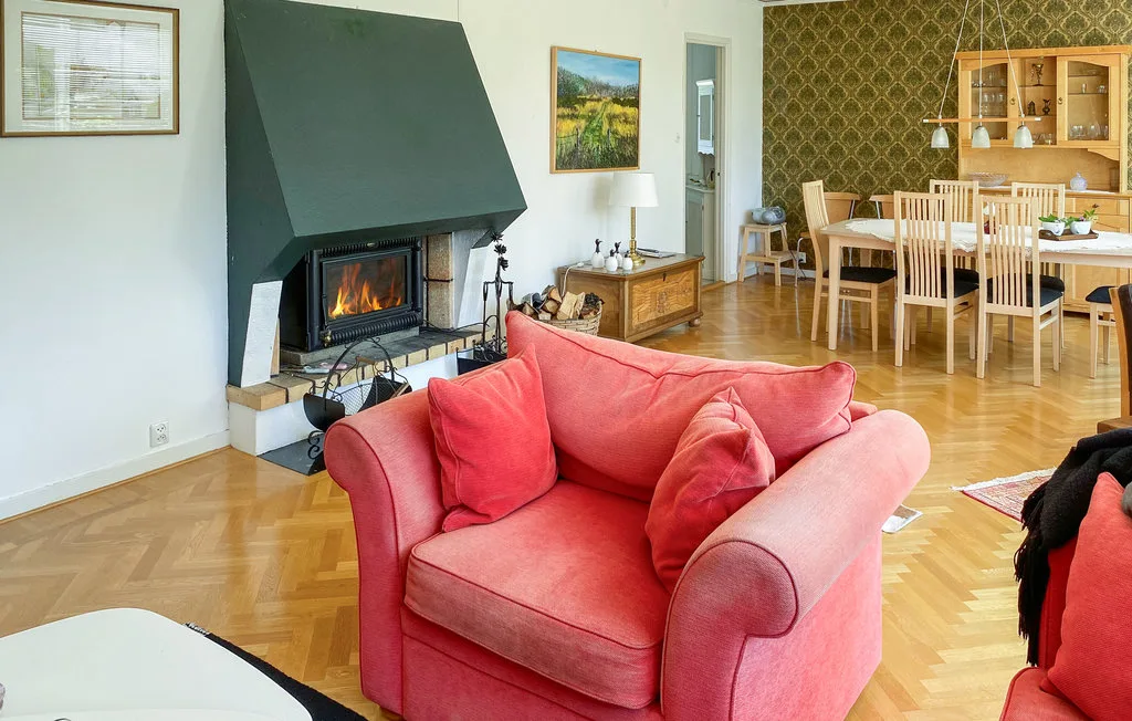 A living and dining area with red seating and a dining table.