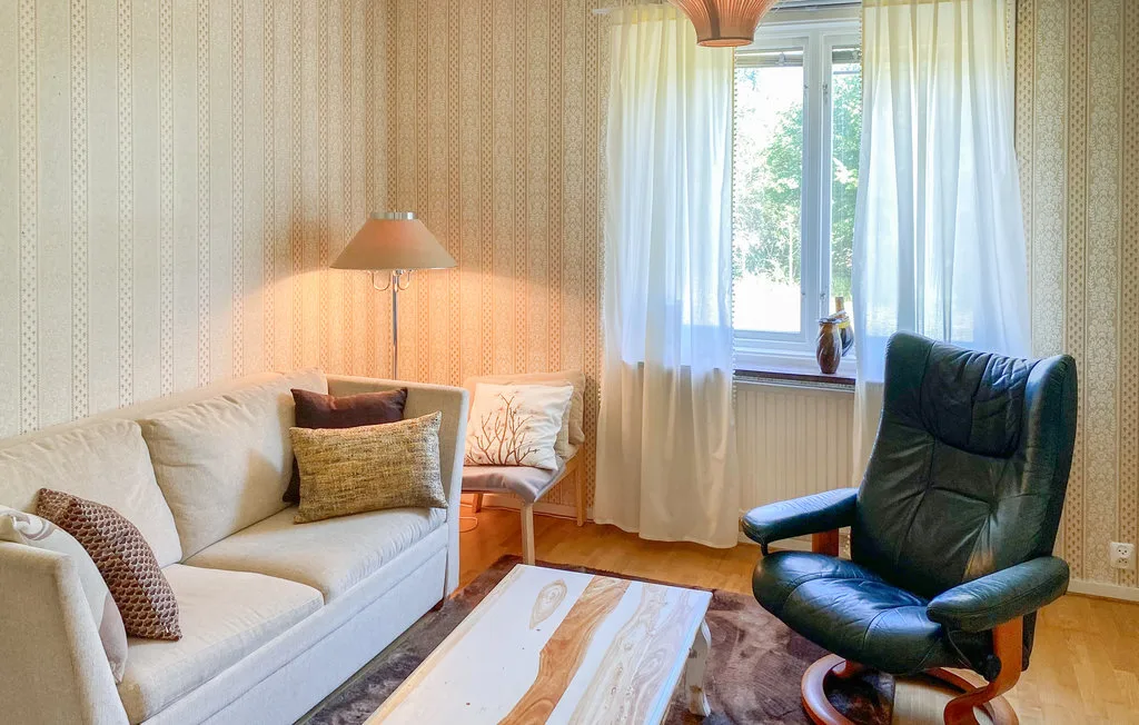 A living room with a sofa, an armchair, and a coffee table.