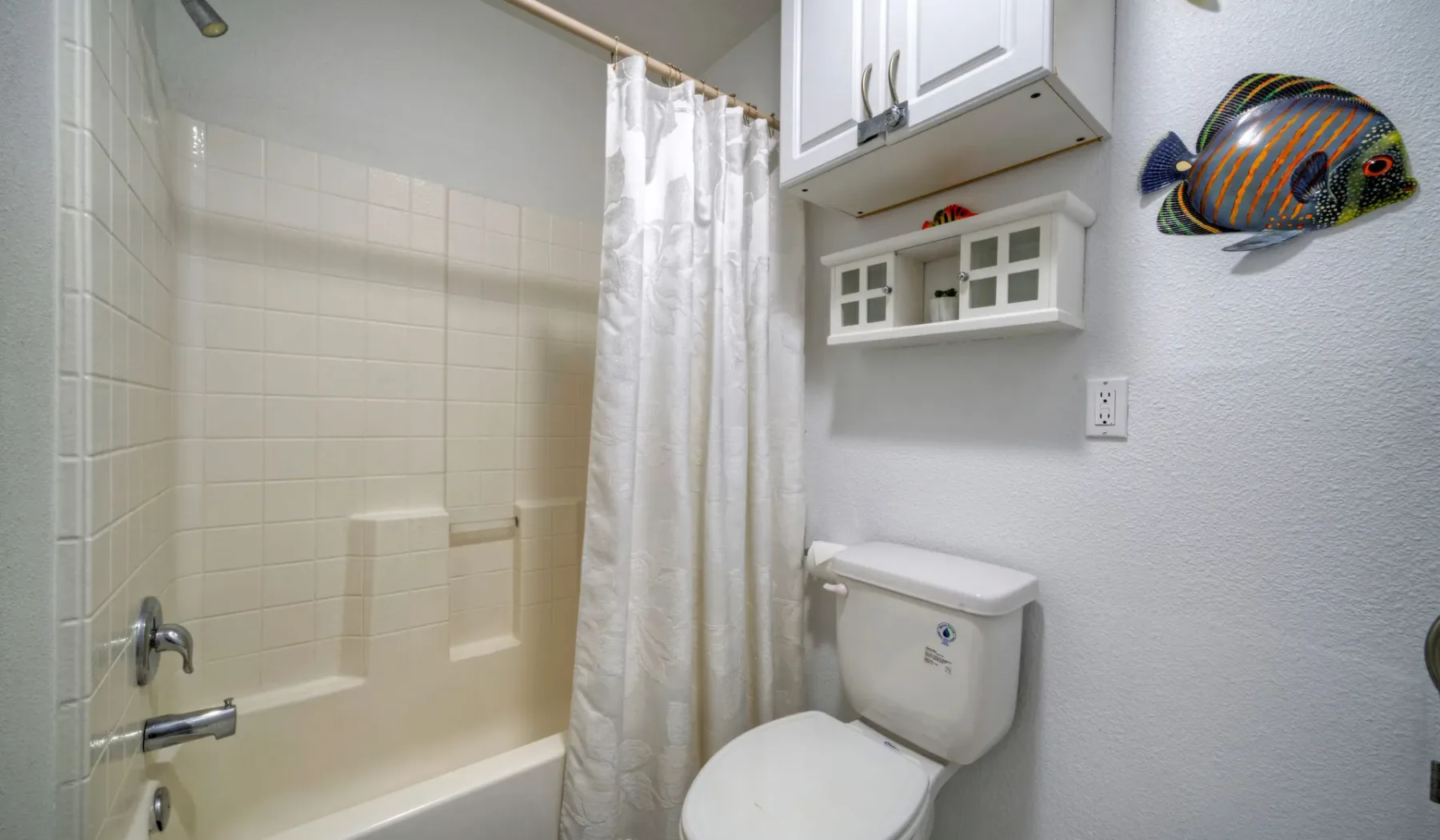 Un baño con bañera, cortina de ducha e inodoro.